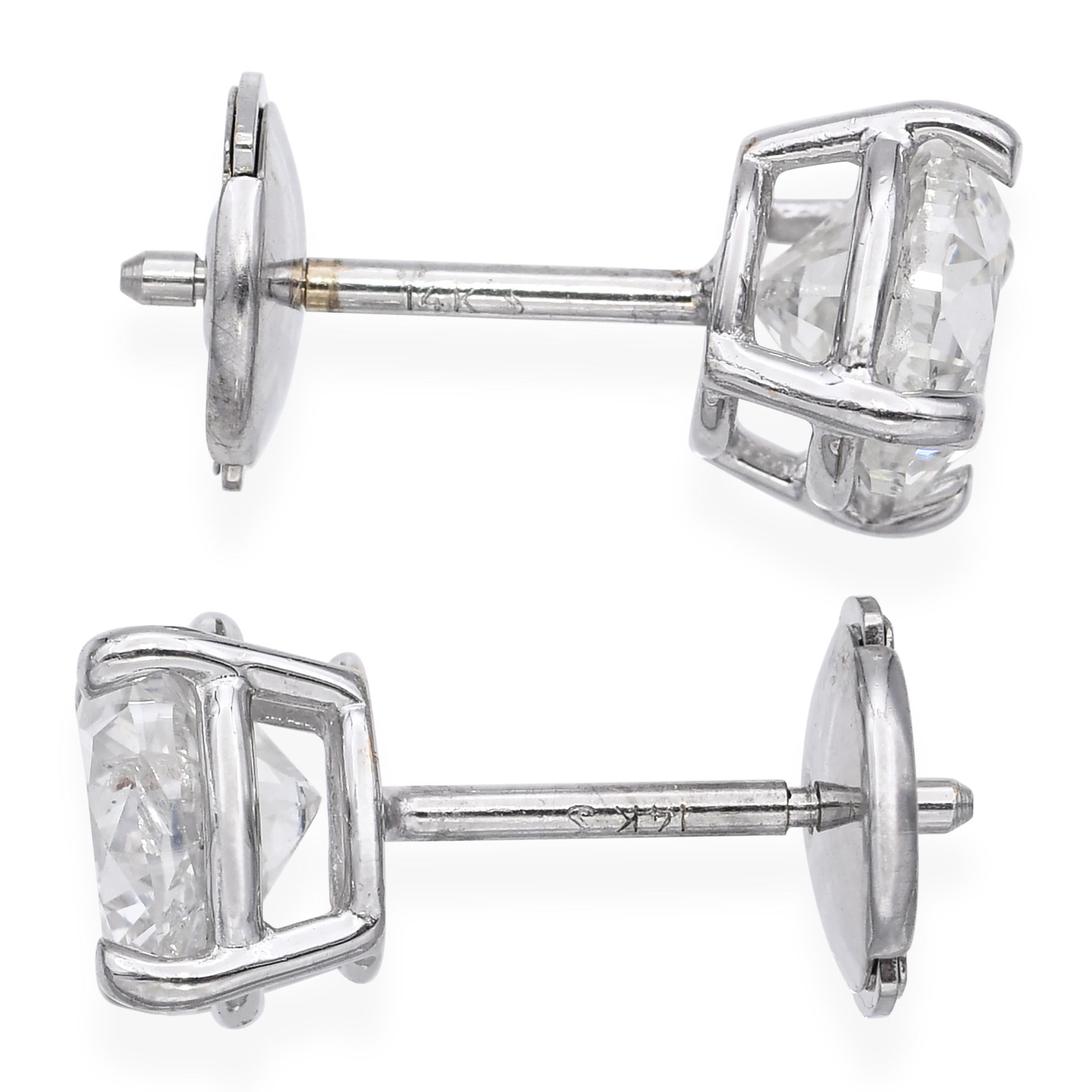 Atemporales y elegantes, estos pendientes vintage de diamantes presentan un peso total en quilates de aproximadamente 1,50 quilates engastados en oro blanco clásico de 14k. Cada pendiente contiene un diamante talla brillante en un engaste