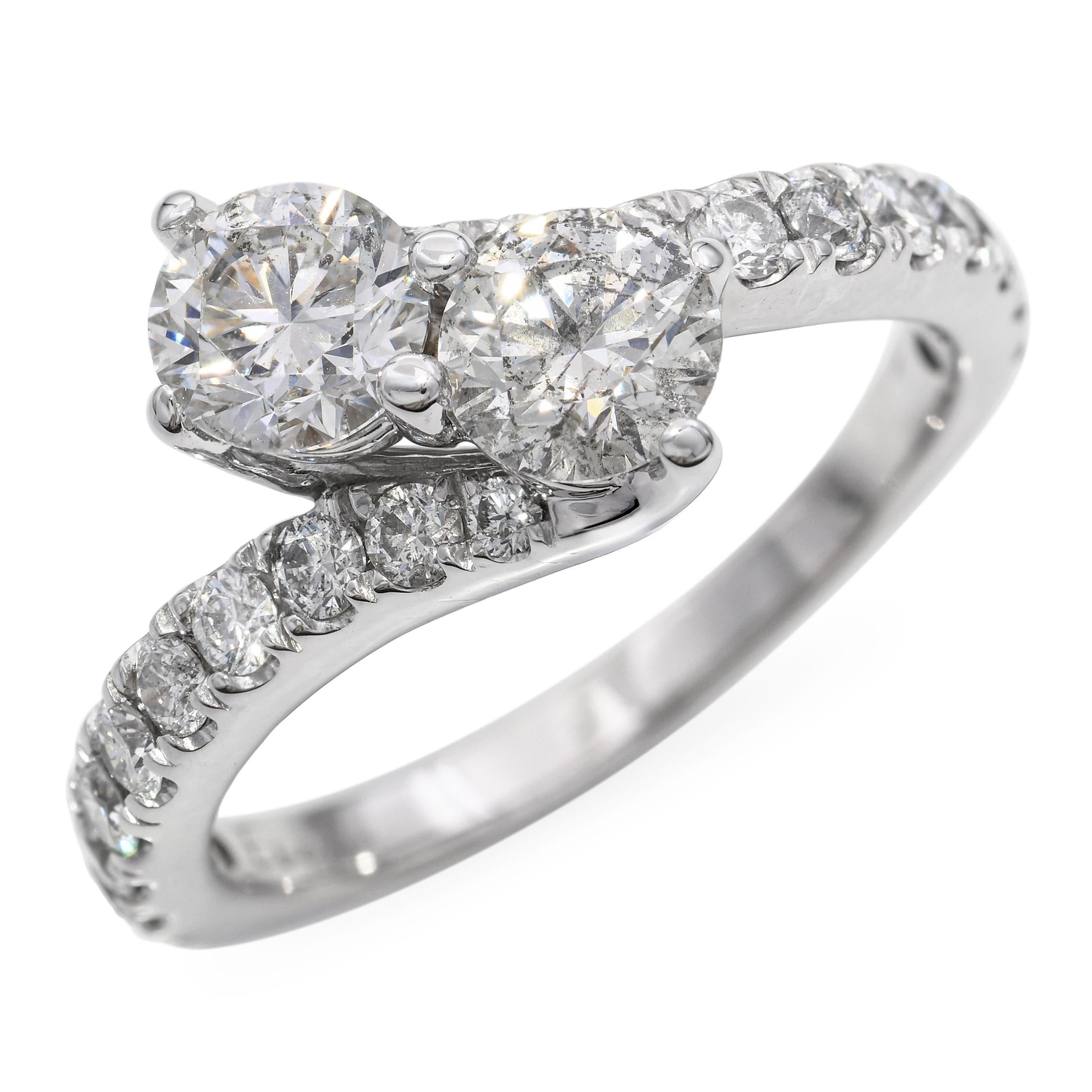 Este elegante anillo vintage Toi et Moi está elaborado en oro blanco de 14 quilates y presenta un elegante diseño en forma de bypass que simboliza dos almas entrelazadas. Engastadas con 1,95 quilates totales de diamantes brillantes, las dos piedras
