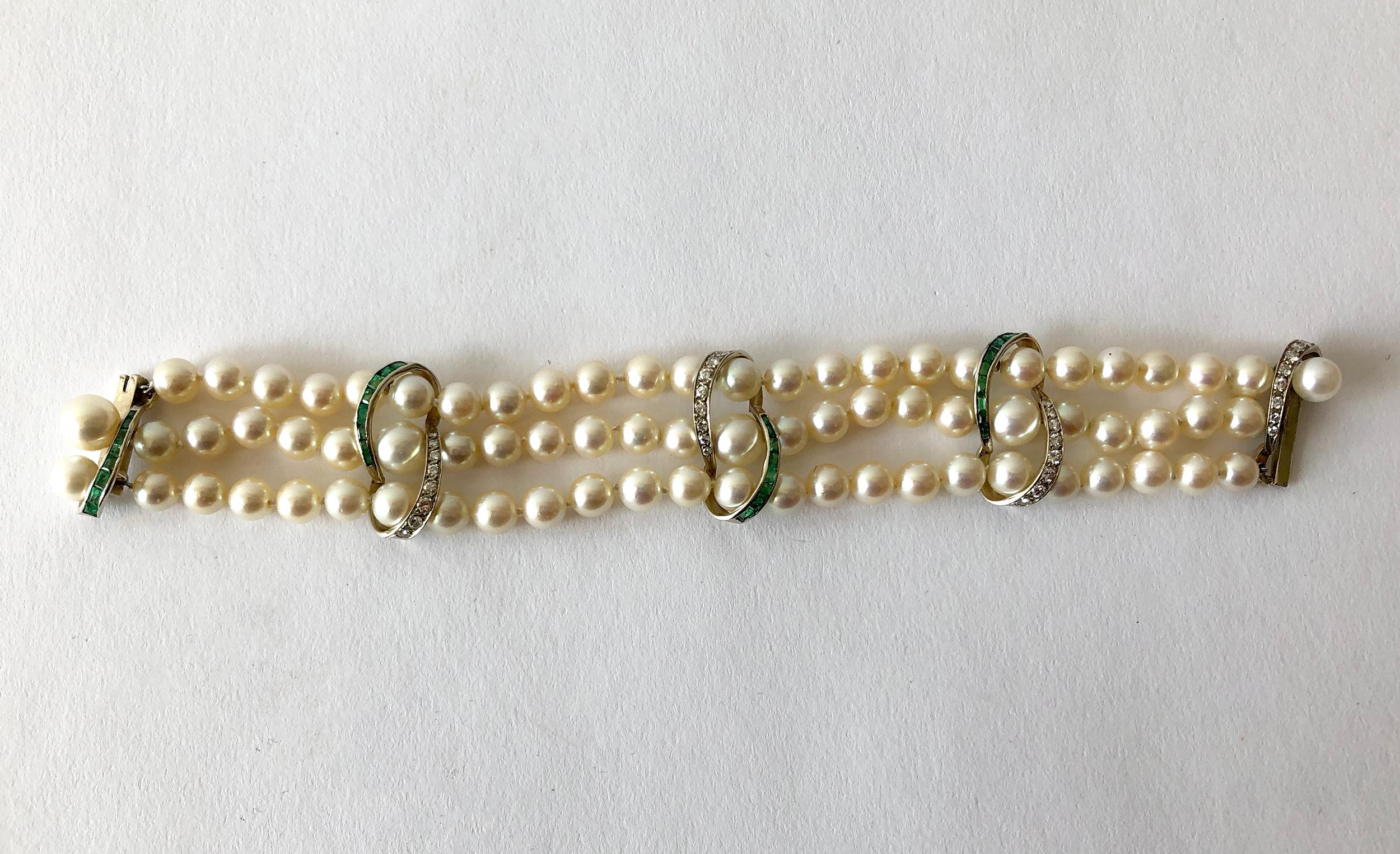 Luxurious three strand pearl bracelet with 14k white gold accents containing channel set emeralds and diamonds.  Emeralds do have natural inclusions and perhaps a small chip or two. These are very hard to see with the naked eye and mostly only under