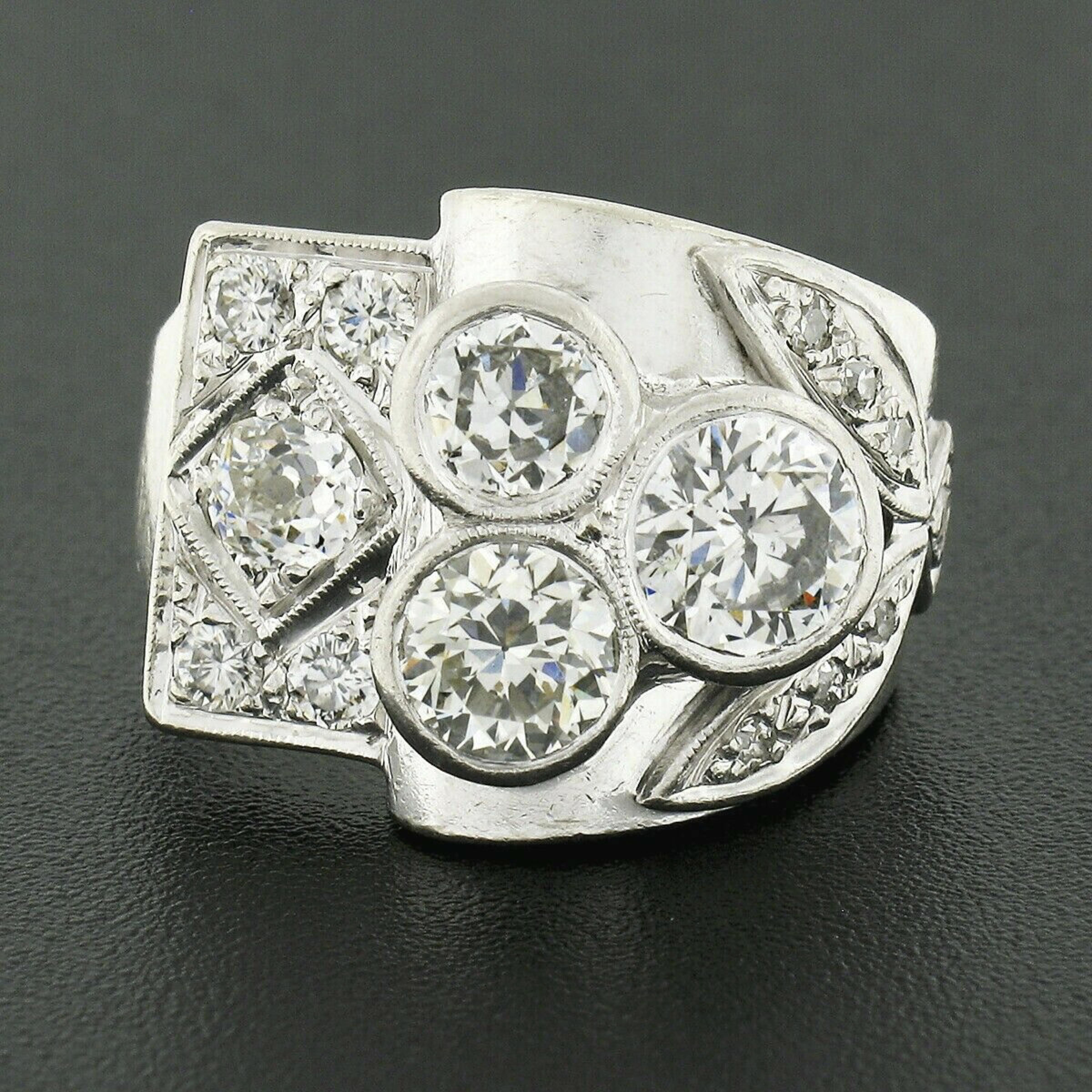 This is an absolutely gorgeous vintage cocktail ring that is crafted in solid 14k white gold featuring a unique design that almost resembles a beautiful bouquet of flowers. It is drenched with approximately 2.32 carats of very fine quality diamonds