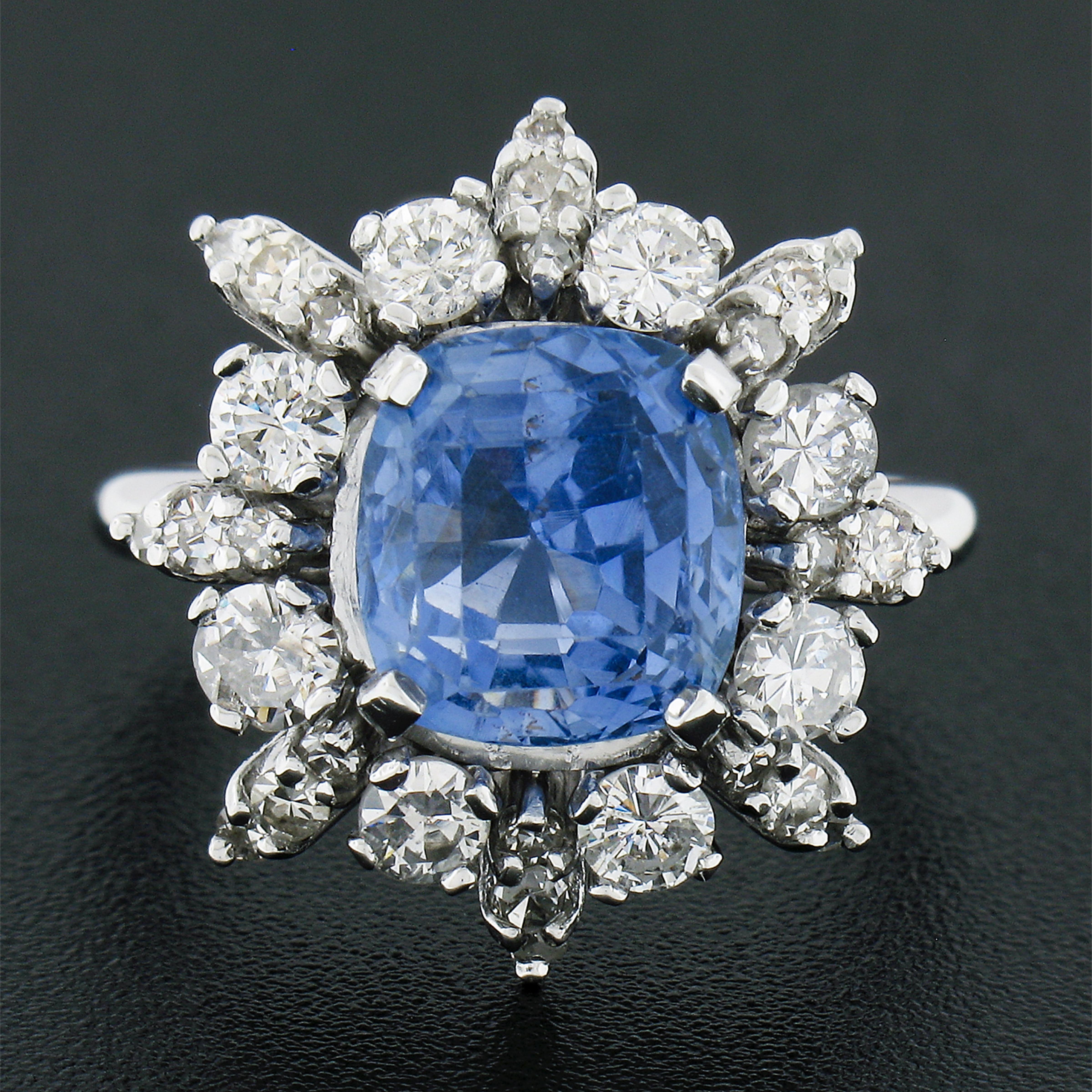 This truly breathtaking engagement or cocktail vintage ring is crafted in solid 14k white gold and features a GIA certified sapphire at its center. The beautiful gemstone has a cushion step cut and displays the most gorgeous cornflower blue color