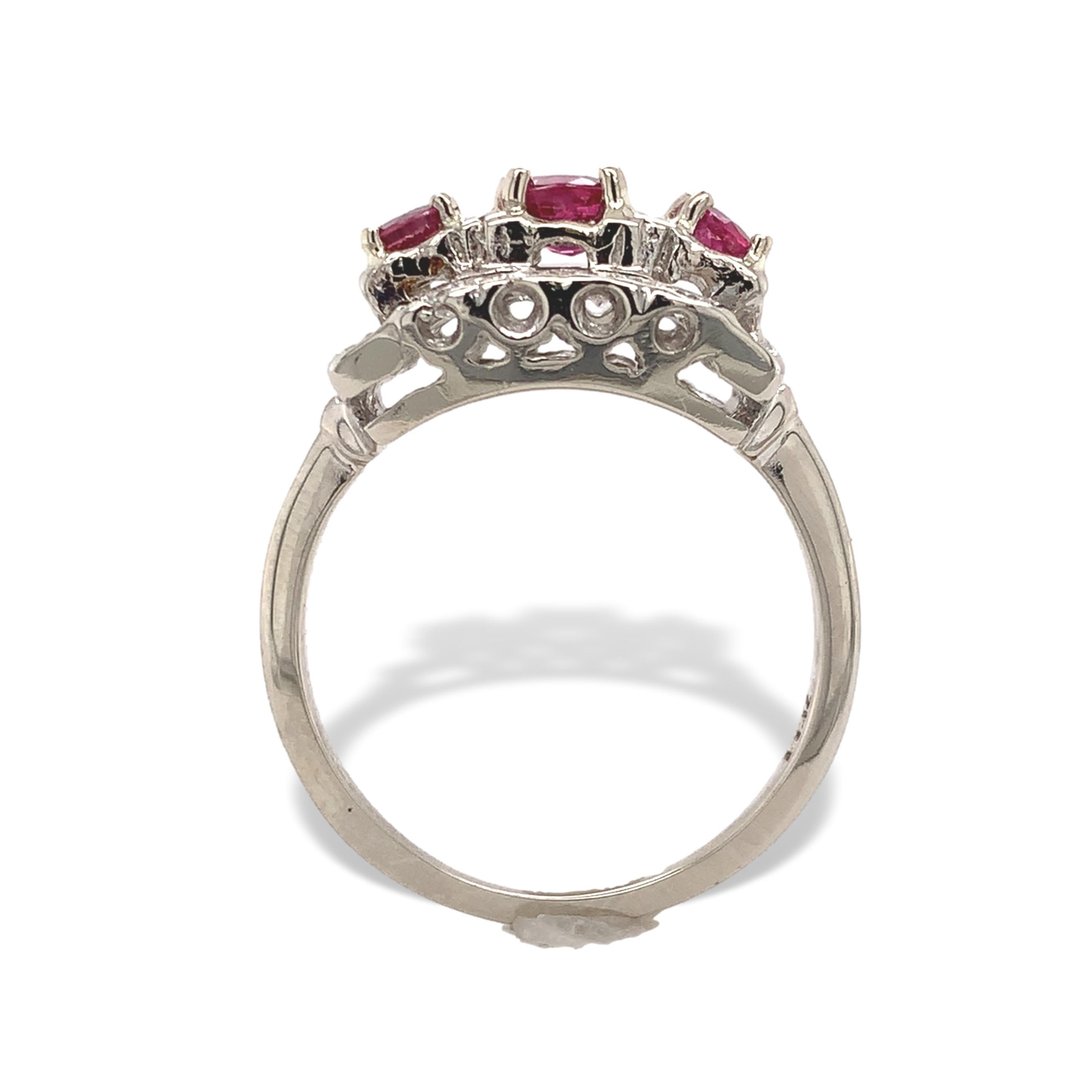 Vintage 14K white gold ruby and diamond band ring. The ring features 3 genuine earth mined round pinkish-red rubies weighing .72cts total. The center ruby measures about 4mm and the 2 smaller rubies measure about 3mm. There are 2 rows of small round
