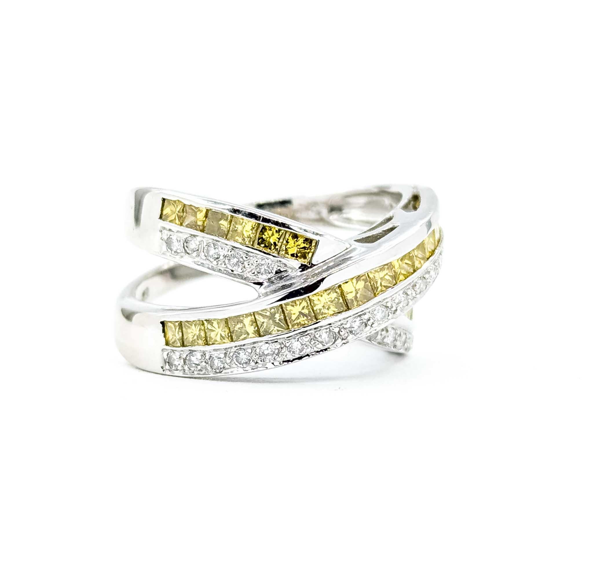 Questo audace ed elegante anello incrociato è realizzato in oro bianco 14 carati e presenta un design sorprendente con diamanti taglio princess e diamanti tondi brillanti. Il pezzo presenta un totale di 1,50 carati di diamanti, con vibranti diamanti