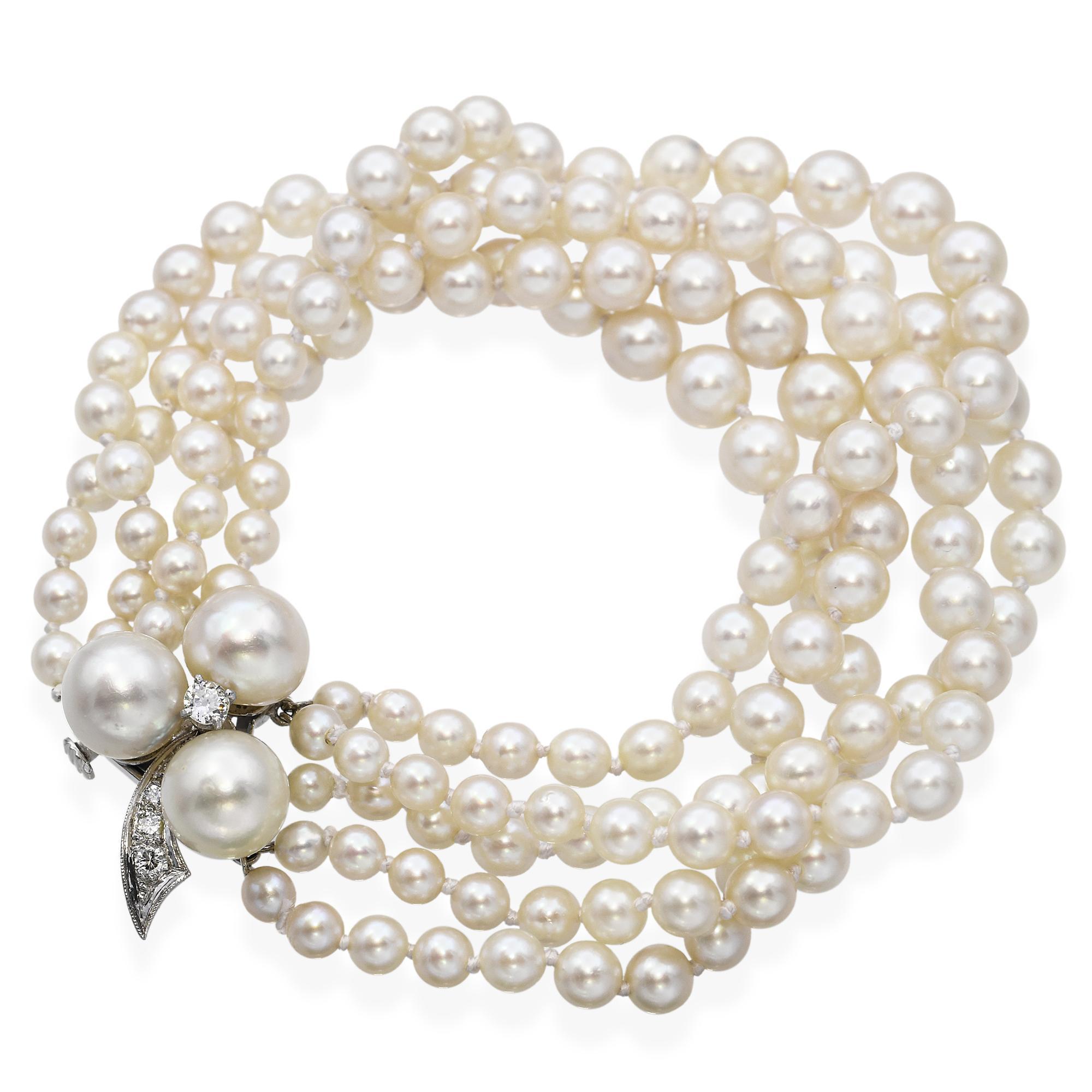 Cet élégant bracelet vintage présente quatre rangs de perles lustrées, gracieusement attachées par un fermoir en or blanc 14k. Le fermoir est orné d'un délicat arrangement de diamants et de perles, mis en valeur par un diamant central étincelant.
