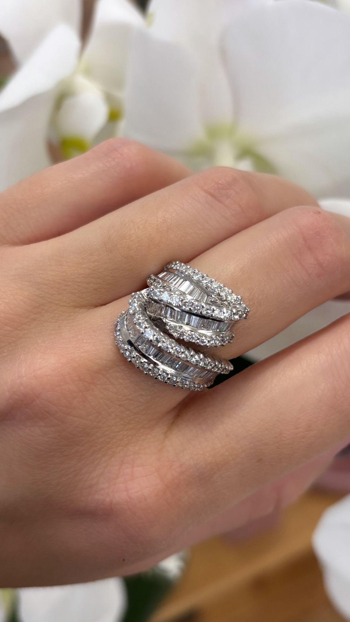 Ein kühner und skulpturaler Vintage-Diamantring aus 14-karätigem Weißgold mit einem eleganten Crossover-Design aus abwechselnden Reihen von Diamanten im Baguette- und runden Brillantschliff. Der Ring ist mit ca. 54 runden Diamanten und 44