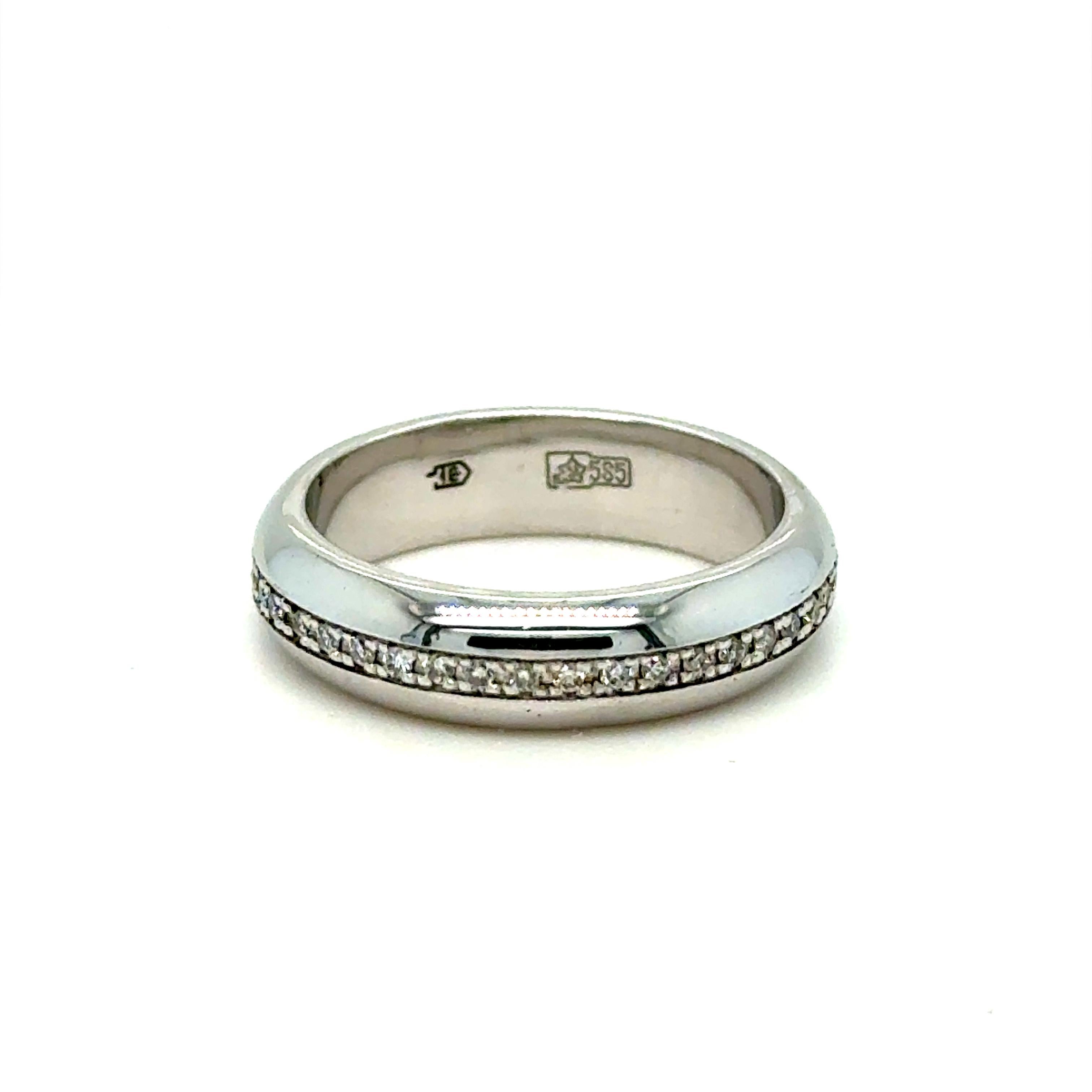 Cet étonnant anneau de mariage éternel à diamants vintage a beaucoup d'éclat pour faire le tour du doigt ! Réalisé en or blanc 14 carats, le bracelet est serti d'environ 60 diamants ronds de taille brillant, totalisant environ 0,50 carat,  de