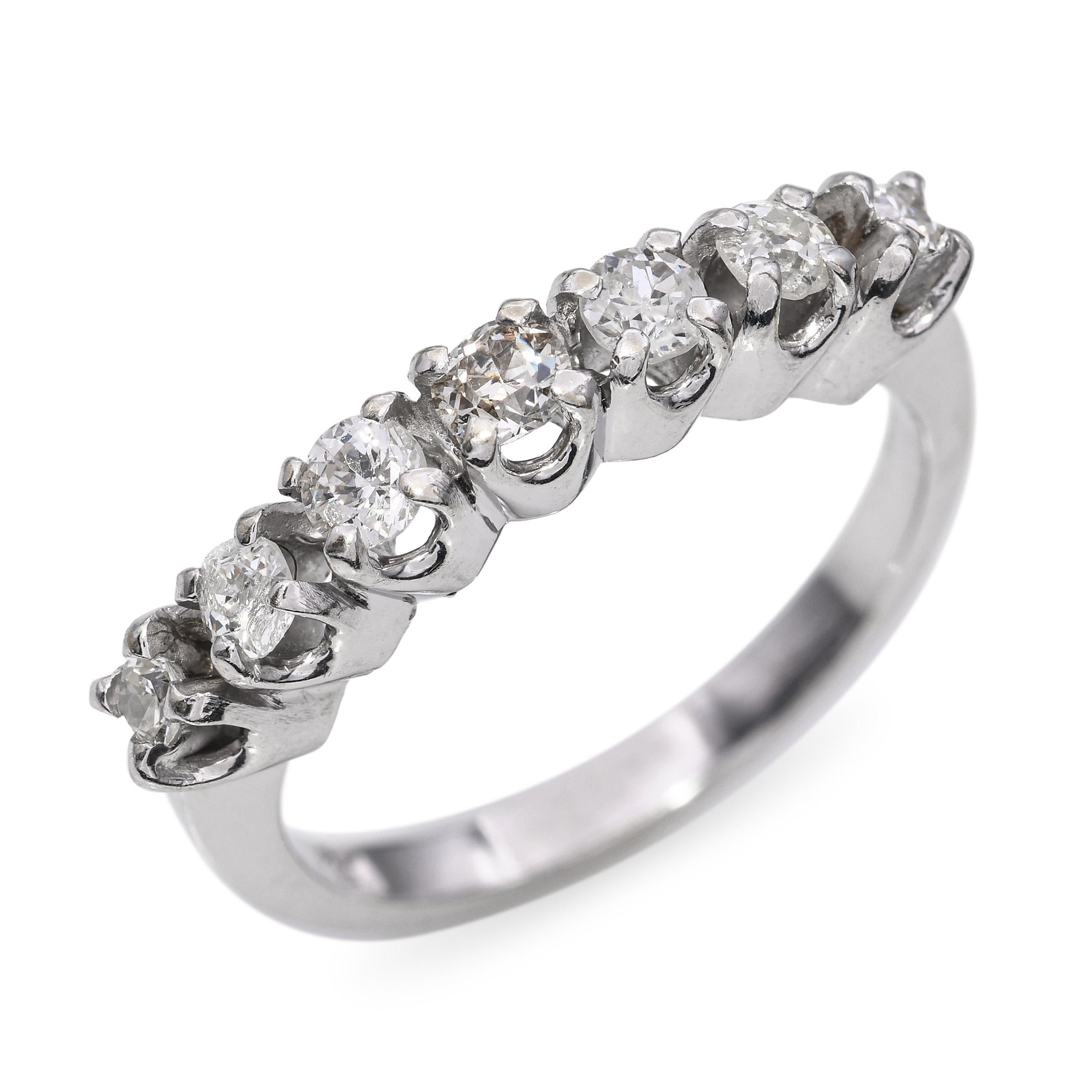 This vintage half band ring is crafted in 14k white gold and set with a row of sparkling brilliant-cut diamonds across the top. The sleek, low-profile design makes it ideal for stacking or wearing alone as a subtle statement. Each diamond is