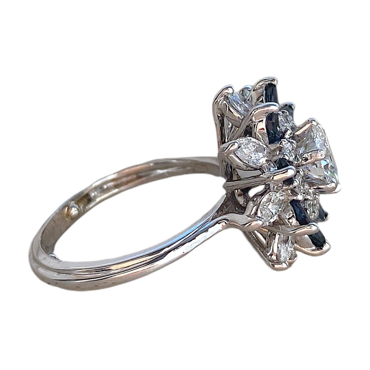 Starburst-Ring im Vintage-Stil aus 14 Karat Weißgold mit einem Diamanten im Brillantschliff in der Mitte. Der Diamant ist von einem Halo aus runden und marquise geschliffenen Diamanten sowie marquise geschliffenen Saphiren umgeben, die ein florales