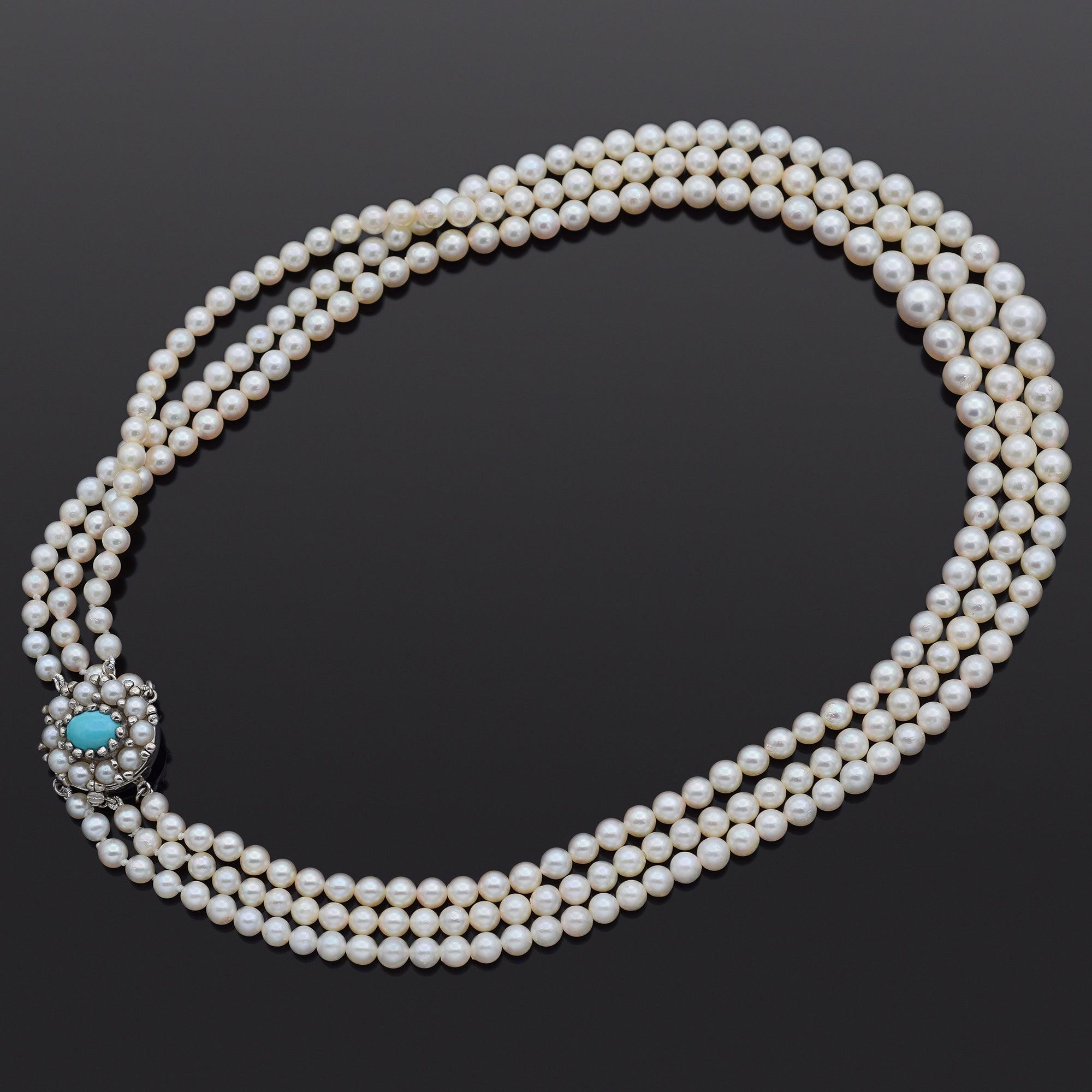 Este collar de perlas graduadas presenta múltiples hilos de luminosas perlas blancas auténticas dispuestas en un elegante diseño en capas. Los hilos se sujetan con un destacado cierre de oro blanco de 14 quilates, engastado con un vívido cabujón
