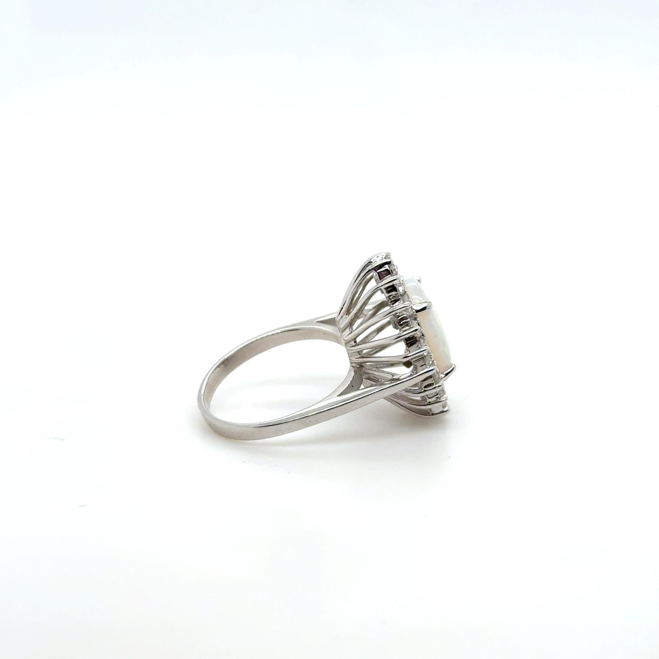 Célébration lumineuse de la couleur et de l'artisanat, cette bague d'inspiration vintage est fabriquée en or blanc 14 carats et met en valeur une opale ovale de 3,00 carats, mesurant 12 mm x 9 mm. Le jeu de couleurs irisé de l'opale - des nuances de
