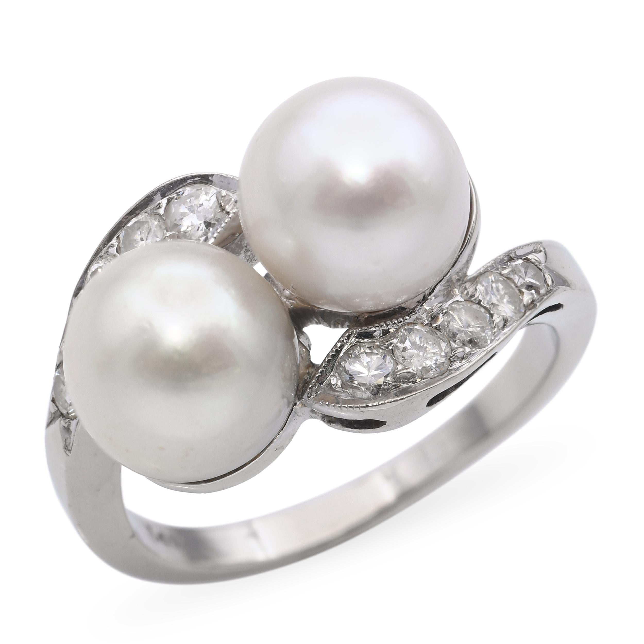 Cette bague vintage en or blanc 14k présente un gracieux design semi-bypass, mettant en valeur une perle lumineuse accentuée par des diamants scintillants. La courbe douce du bracelet crée une silhouette élégante et fluide qui s'enroule doucement