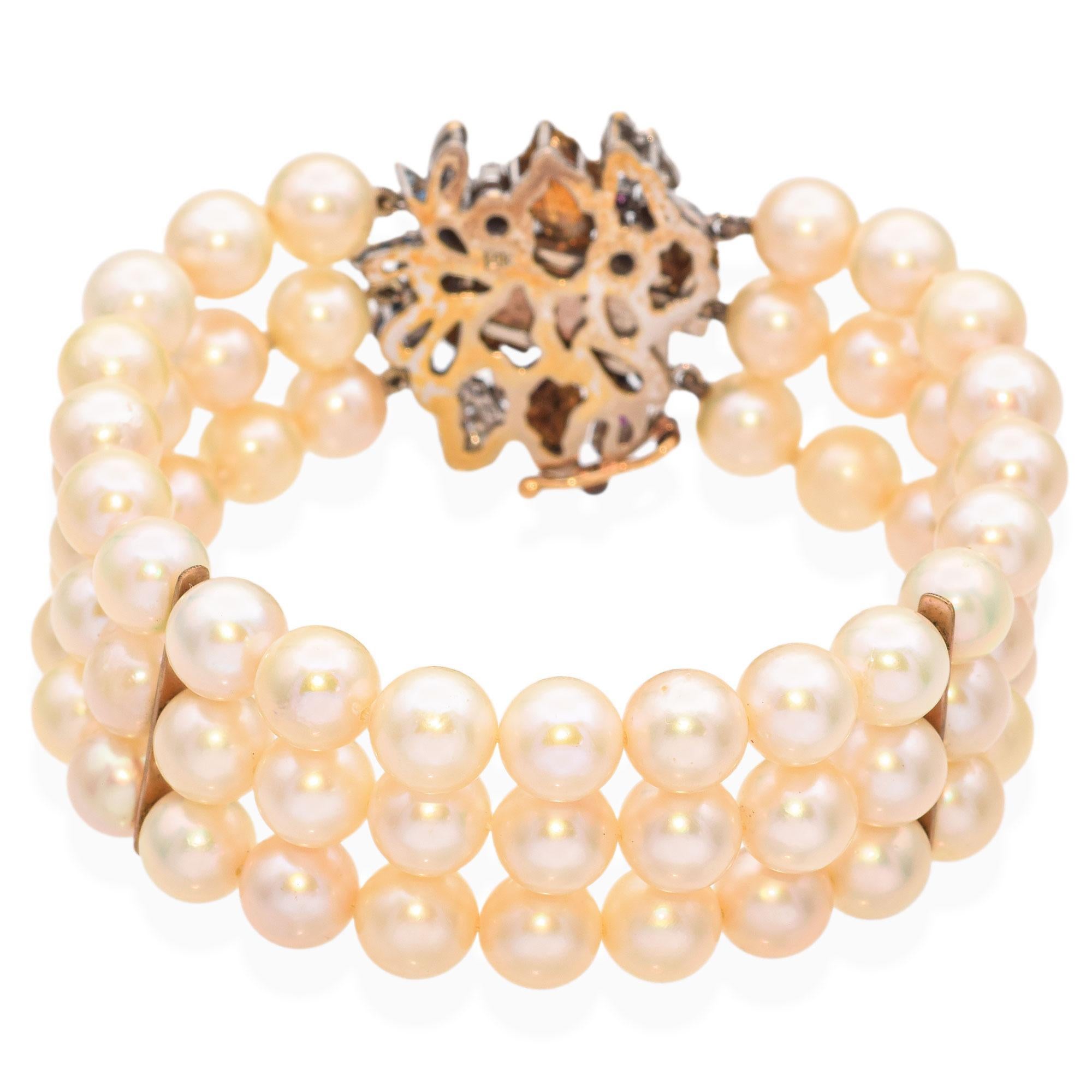 This vintage 14k yellow and white gold bracelet showcases a stunning combination of pearls, rubies, sapphires, and diamonds. The vibrant gemstones are elegantly set between lustrous pearls, creating a rich tapestry of color and sparkle. The two-tone