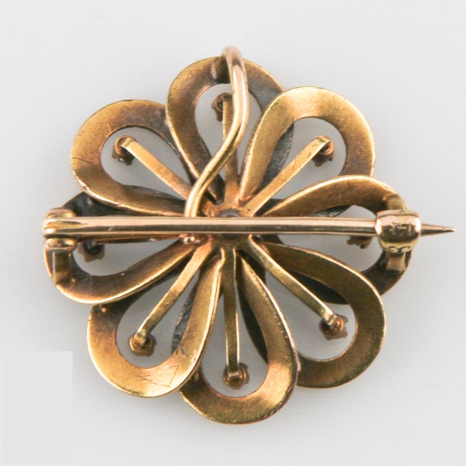 14K Yellow Gold & Enamel Brooch
Features Overlapping Gold Ribbon Loops w/ Delicate Floral Enamel Designs
Total wight Of Diamonds: Approximately 0.45 cts. 
Hallmarks: 14K 
Size: 25 mm In Diameter
Total Mass = 6.2 grams