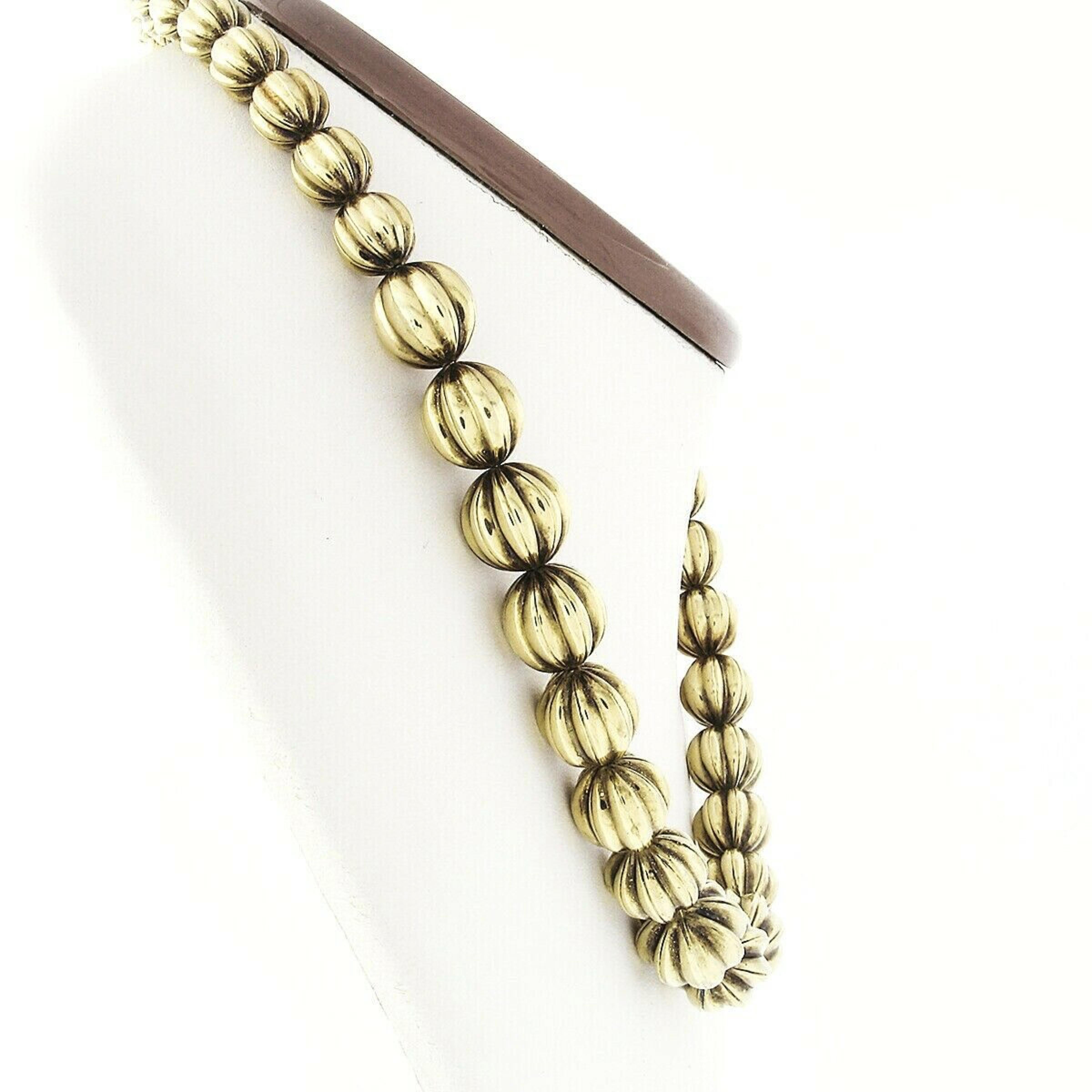 Here we have a gorgeous vintage necklace that was crafted in Italy from solid 14k yellow gold. It features 38 grooved and puffed gold ball beads that graduate in size from approximately 8.45mm at the back to approximately 13mm at the front. The