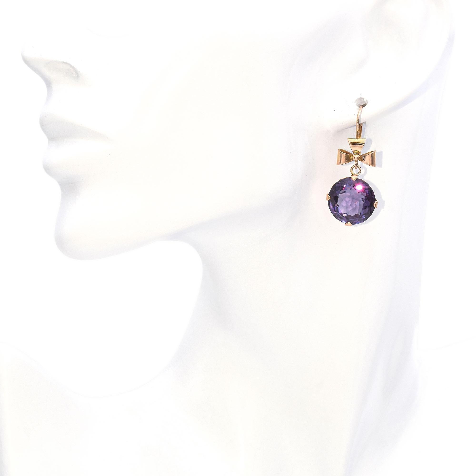 Indulge in these captivating dangle earrings featuring 21.2 carats of stunning round alexandrite. These breathtaking earrings are crafted in radiant yellow gold, perfectly complementing the rich purple hues of the round-cut alexandrite stones. The