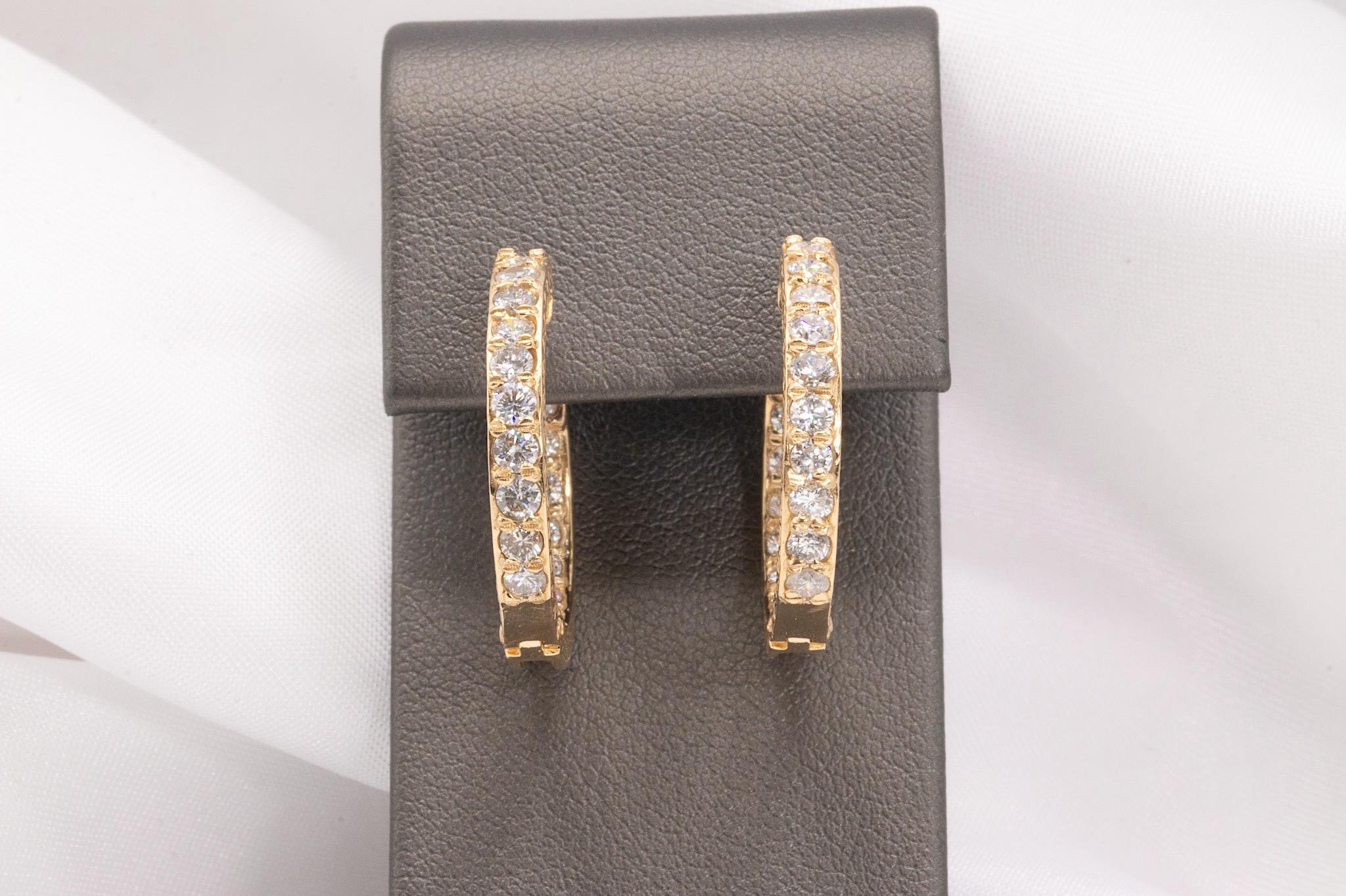 These stunning vintage diamond hoop earrings, crafted in 14K yellow gold, feature a unique and captivating design. Each earring is adorned with 10 round brilliant diamonds on the front and 8 on the inside of the hoop, totaling 36 diamonds across