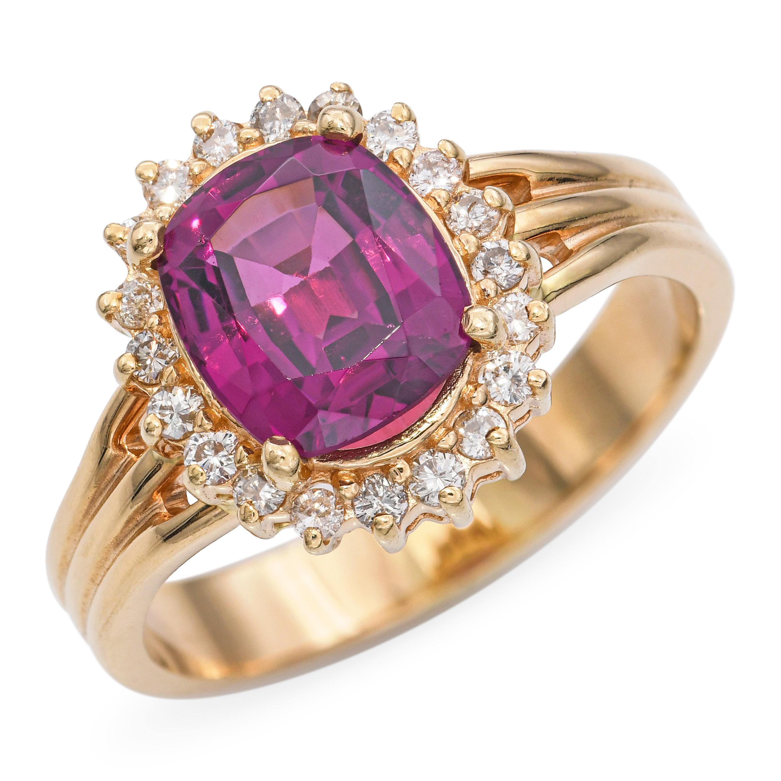 This vintage ring is crafted in 14k yellow gold and showcases a richly hued 2.30-carat rhodolite garnet at its center. Surrounding the garnet is a halo of sparkling diamonds, adding brilliance and enhancing the gemstone’s vibrant purplish-red tone.