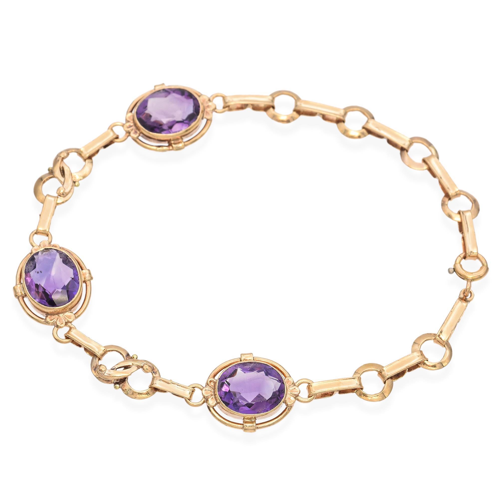 Elegantly crafted in 14k yellow gold, this link bracelet showcases a trio of captivating oval-cut amethysts, each exuding a rich purple hue. The amethysts, totaling 6.0 carats, are securely set within intricate gold frames, connected by a series of