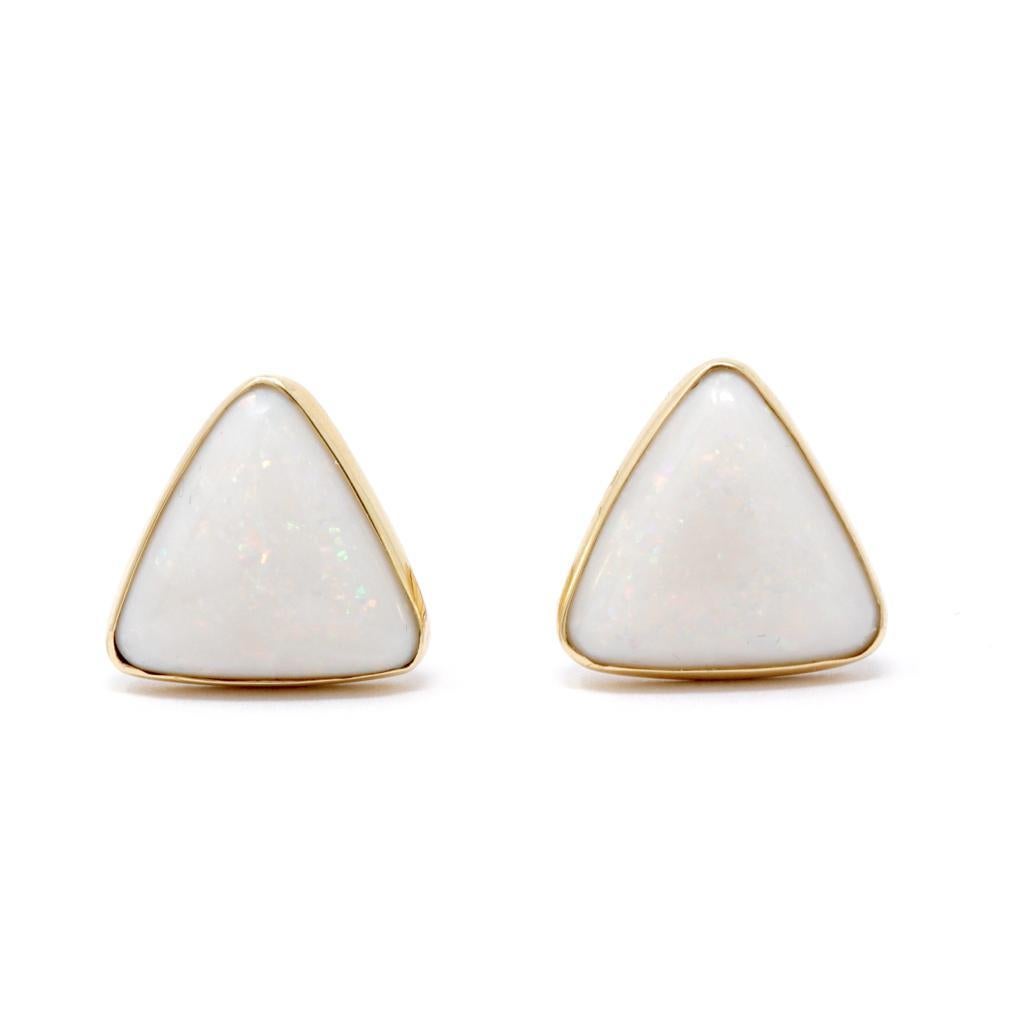 Vintage 14K Yellow Gold and White Opal Cufflinks. The opals are a triangular cabochon cut of a a semi-translucent to opaque white body with pin-point play of color in green, yellow, orange and lavender. Each stone set within a yellow gold frame