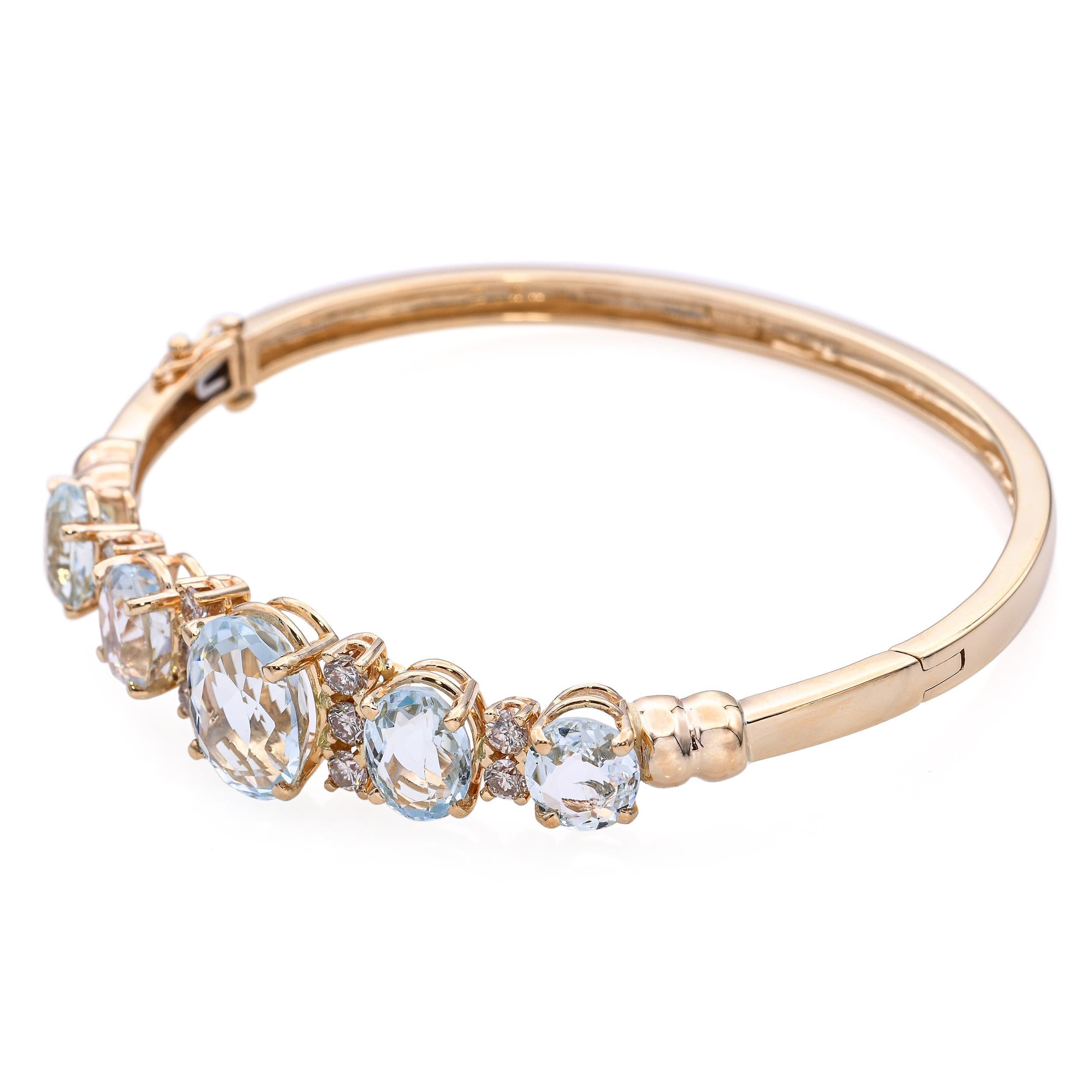 Questo bracciale bangle vintage in oro giallo 14k presenta un design raffinato incentrato su una vibrante gemma acquamarina, accentuata da diamanti scintillanti. La struttura a cerniera offre comfort e sicurezza, mentre le linee pulite e la presenza