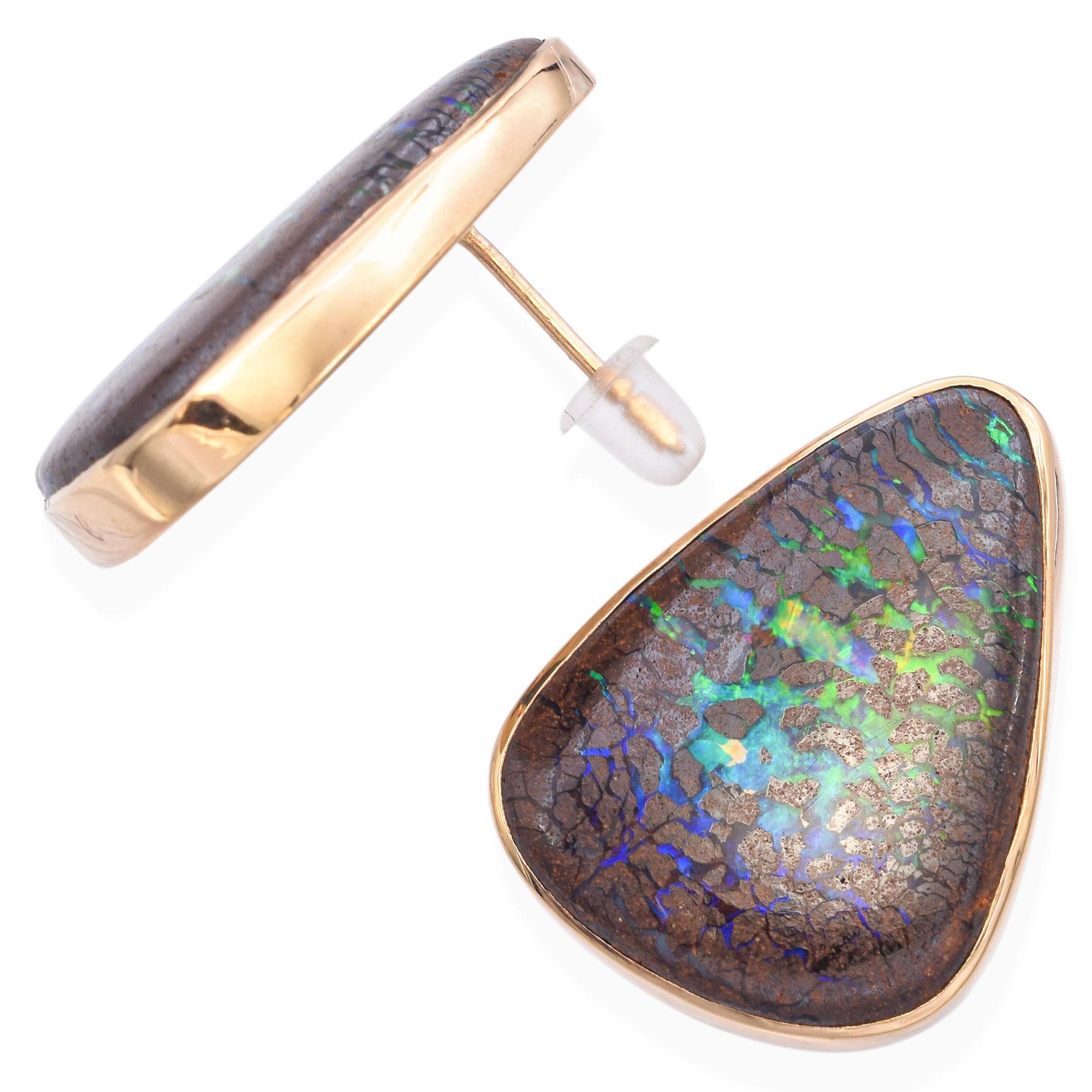 Ces boucles d'oreilles saisissantes présentent un jeu de couleurs envoûtant avec des verts et des bleus vibrants sertis sur une matrice d'un brun riche et terreux. La forme organique en goutte d'eau est accentuée par une finition lisse et polie,