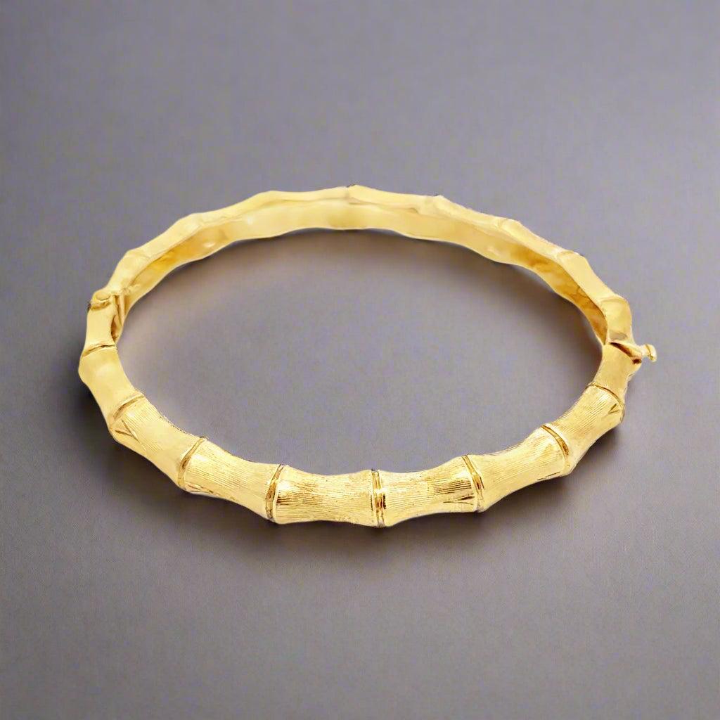 Questo braccialetto stile bambù in oro giallo 14K Vintage presenta una finitura in oro spazzolato e un classico design a bambù, che incarna l'eleganza senza sforzo dello stile di Palm Beach. Perfetto per essere indossato tutti i giorni, si abbina