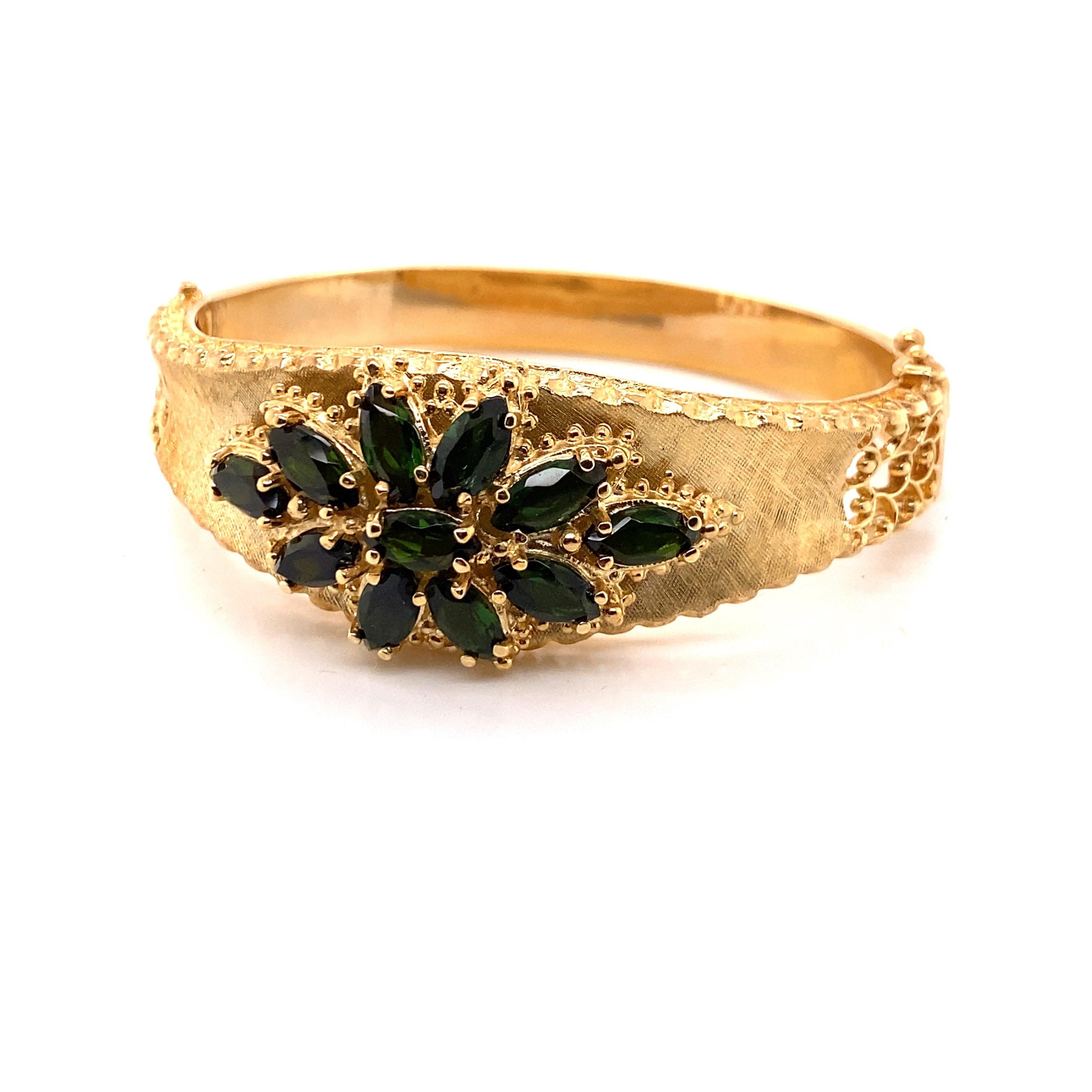 Vintage 14K Yellow Gold Bangle Bracelet with Green Tourmaline - There are 11 marquise shape green tourmalines set in a flower design. The gold bangle has a florentine finish with some filigree work on the side. The width on the top is 21 mm and