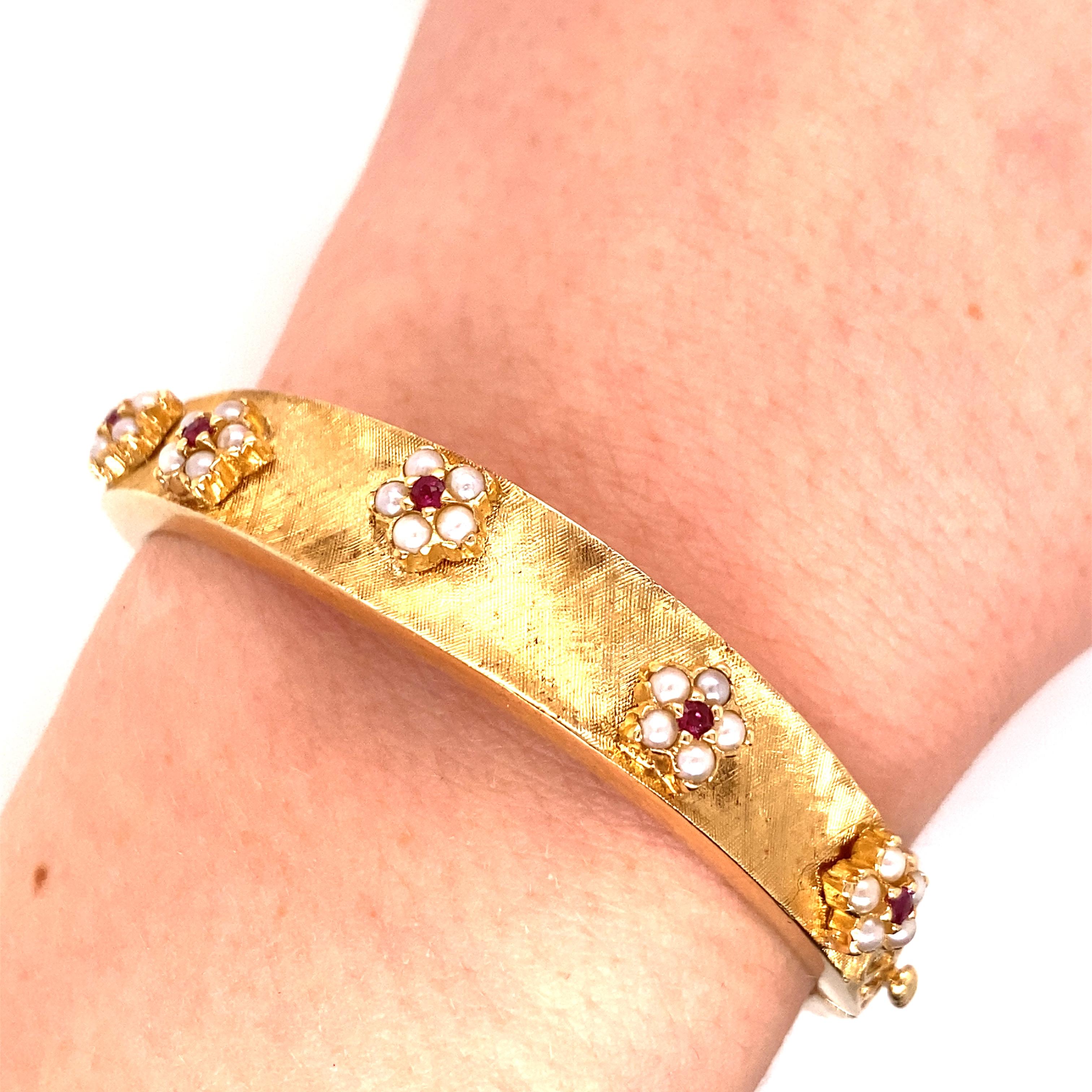 Vintage 14K Yellow Gold Bangle Bracelet with Ruby and Pearl Flowers -  There are 5 flowers scattered on top with a florentine/brushed finish on the gold. There is some filigree detail on the side as well.The width of the bangle is 10.3mm on top and