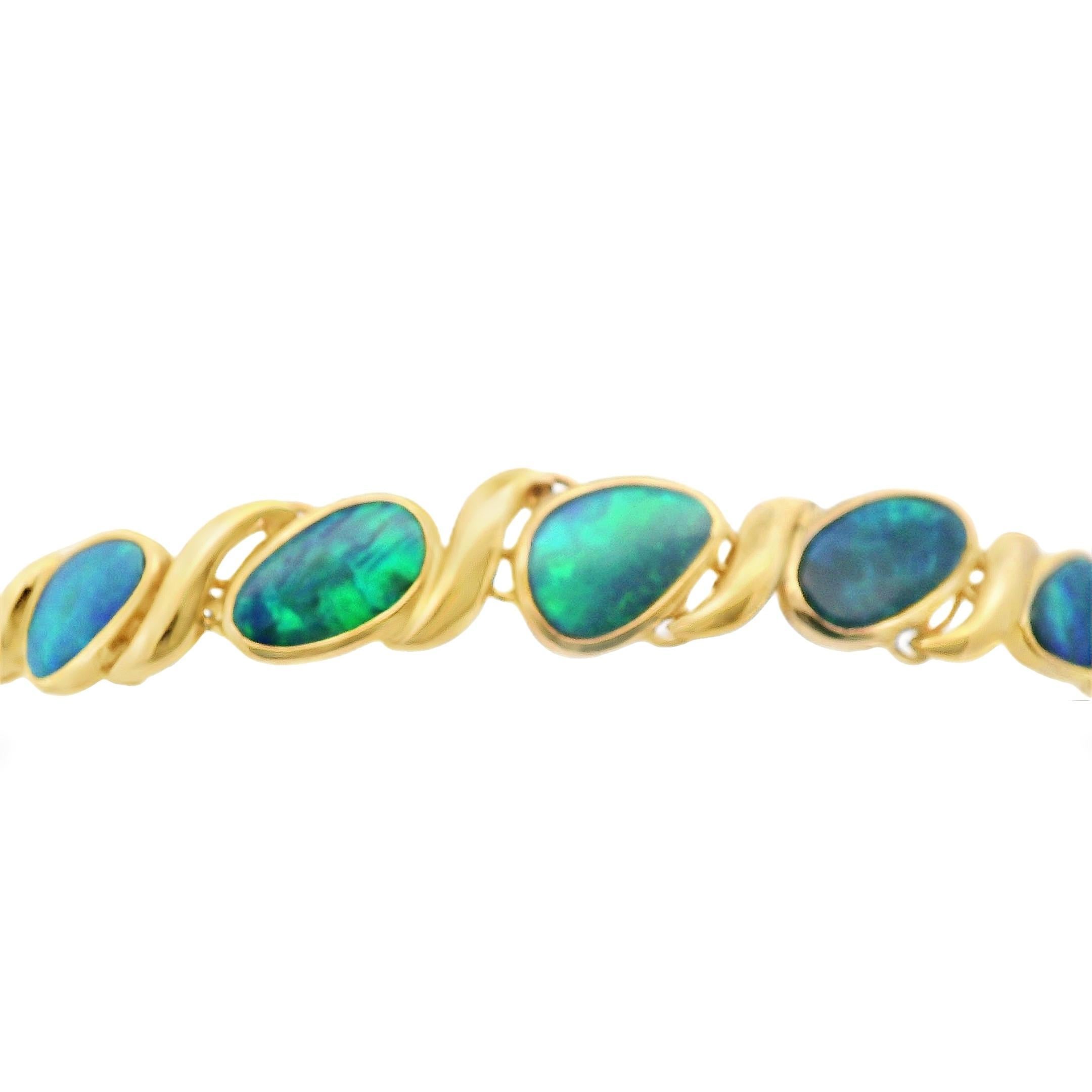 This colorful work of art is a vintage 14k yellow bracelet with bezel set freeform tablets of black opal. There are a total of 6, freeform shaped, black opals with excellent play of color and various flashy shades of fire like green and blues. Each