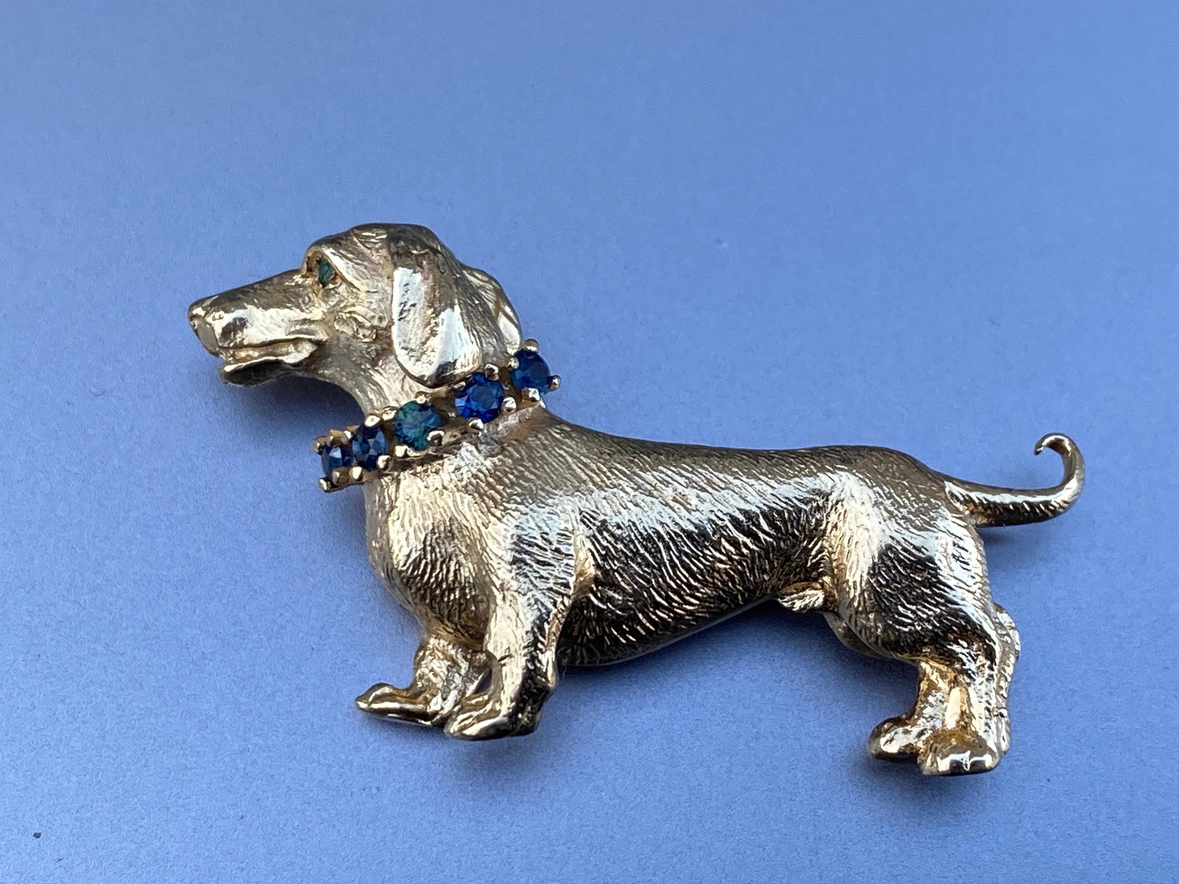 Up for your consideration is this delightful figural dachshund dog brooch, pin.

From the mid-twentieth century, this charming dog is finely modeled  to show off his fur and a lustrous finish.  The pup is adorned with .20cttw of blue faceted
