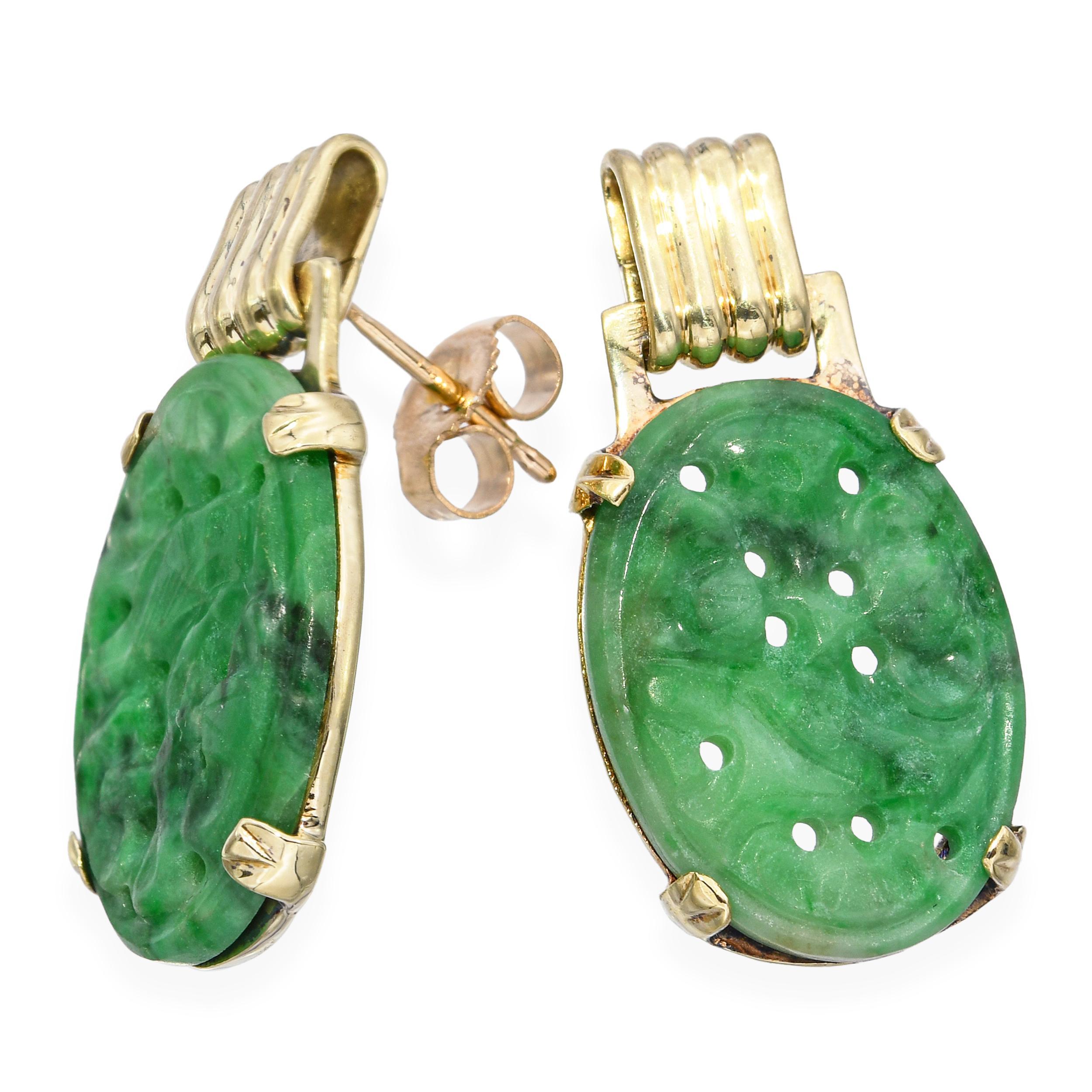A beautiful pair of vintage earrings crafted in 14k yellow gold featuring intricately carved jade plaques, showcasing traditional artistry and a serene green hue. The earrings display fine detail and rich color, mounted in simple gold frames that