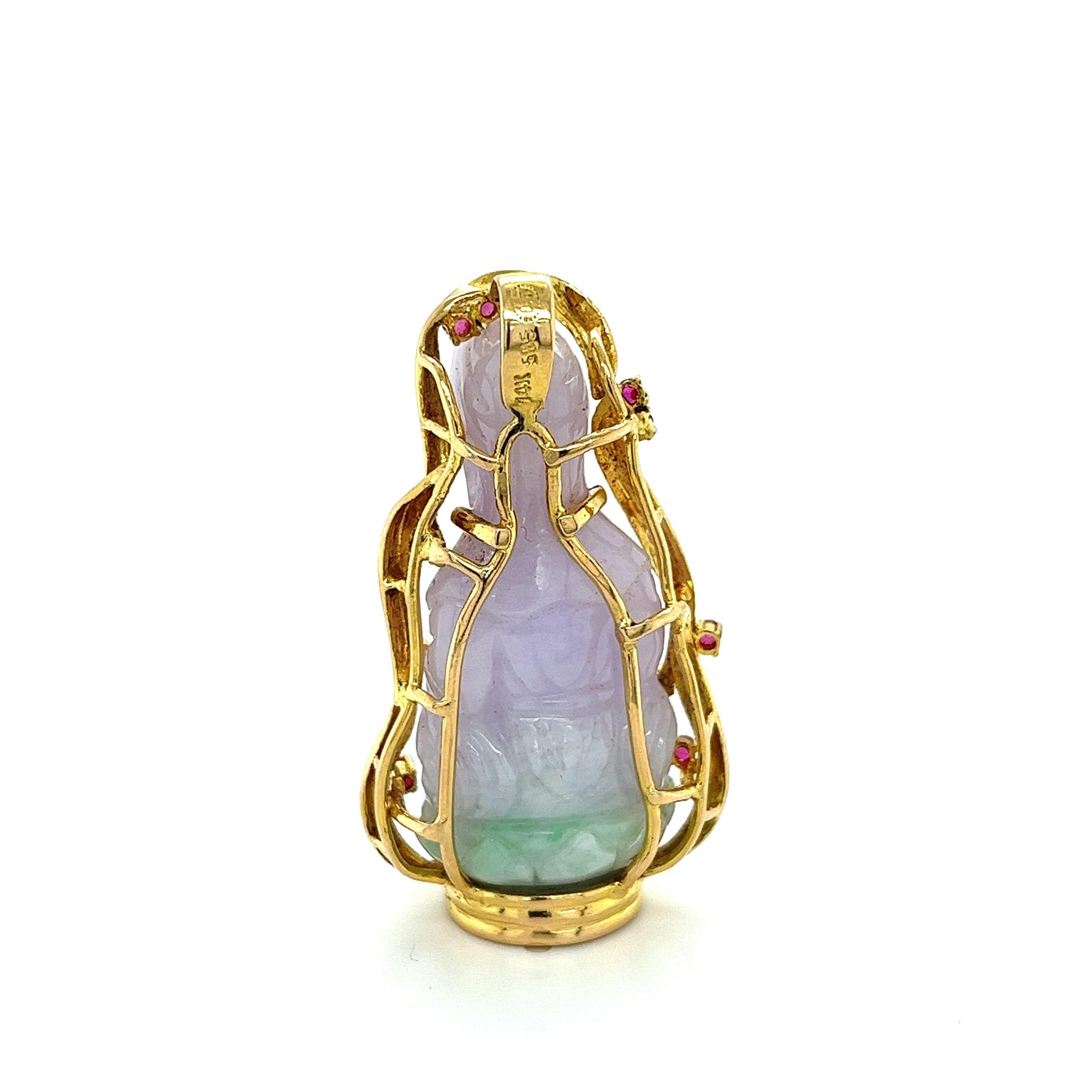 Introducing a beautifully crafted jade Buddha pendant, made from a mixed color of lavender and green jade and set in 14k yellow gold. This stunning pendant features intricate carvings of a seated Buddha, surrounded by 11 round-cut vibrant rubies on