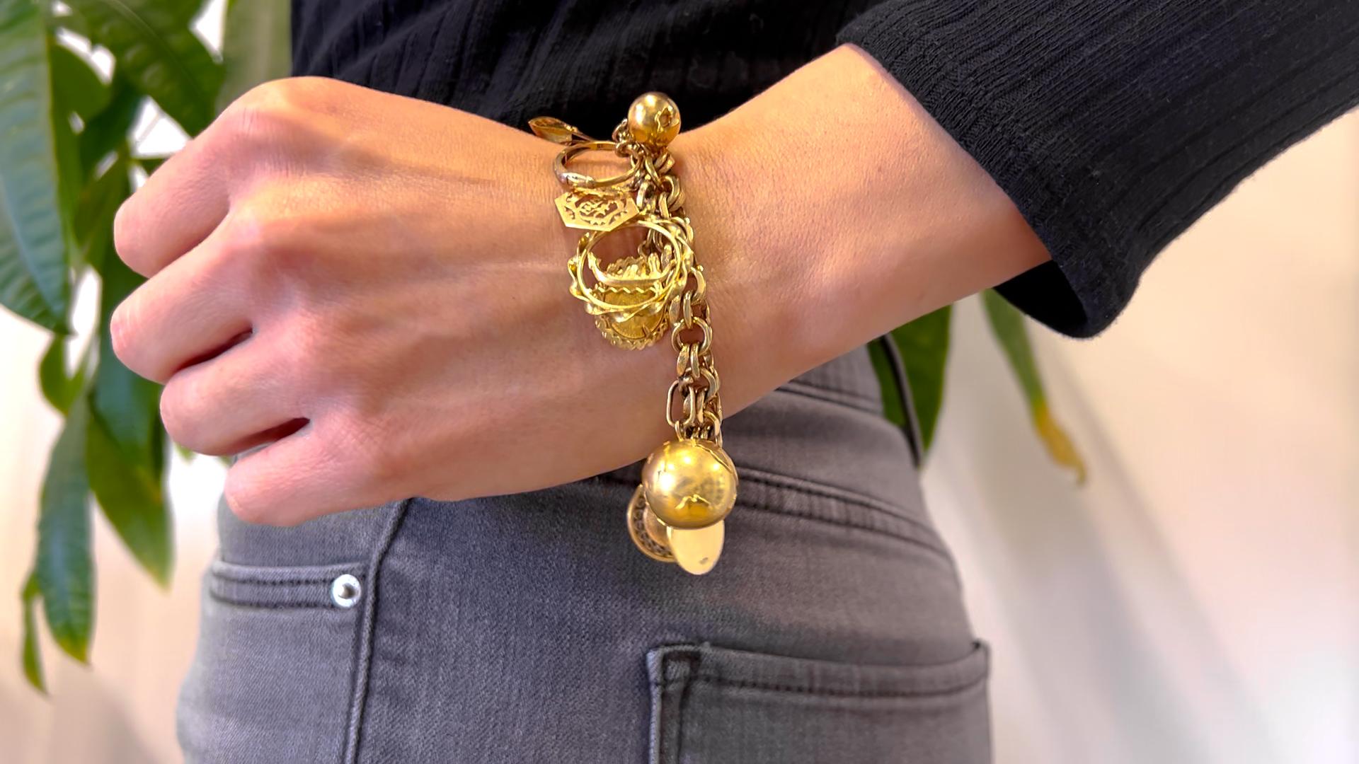 Ein Vintage 14k Gelbgold Charm Armband. Ein Gliederarmband aus 14-karätigem Gelbgold. Die meisten Charms sind aus 14-karätigem Gelbgold, ein paar aus 18-karätigem Gelbgold und ein Charme ist vergoldet. CIRCA 1900-1980. Wiegt 62,34 Gramm. Der Armreif