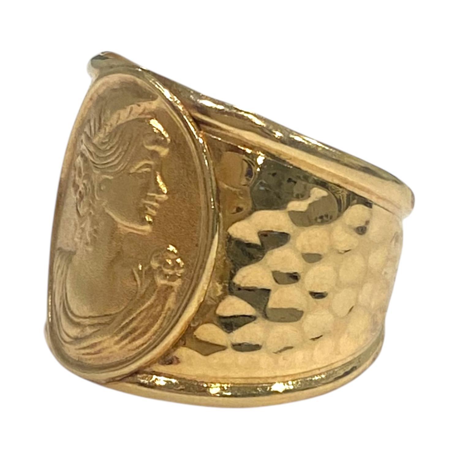 Realizzato in oro giallo 14K, questo anello a fascia presenta un intricato disegno a cammeo in stile art nouveau. L'ampia fascia presenta un rilievo dettagliato di un profilo femminile classico, incorniciato da un medaglione ovale. La texture