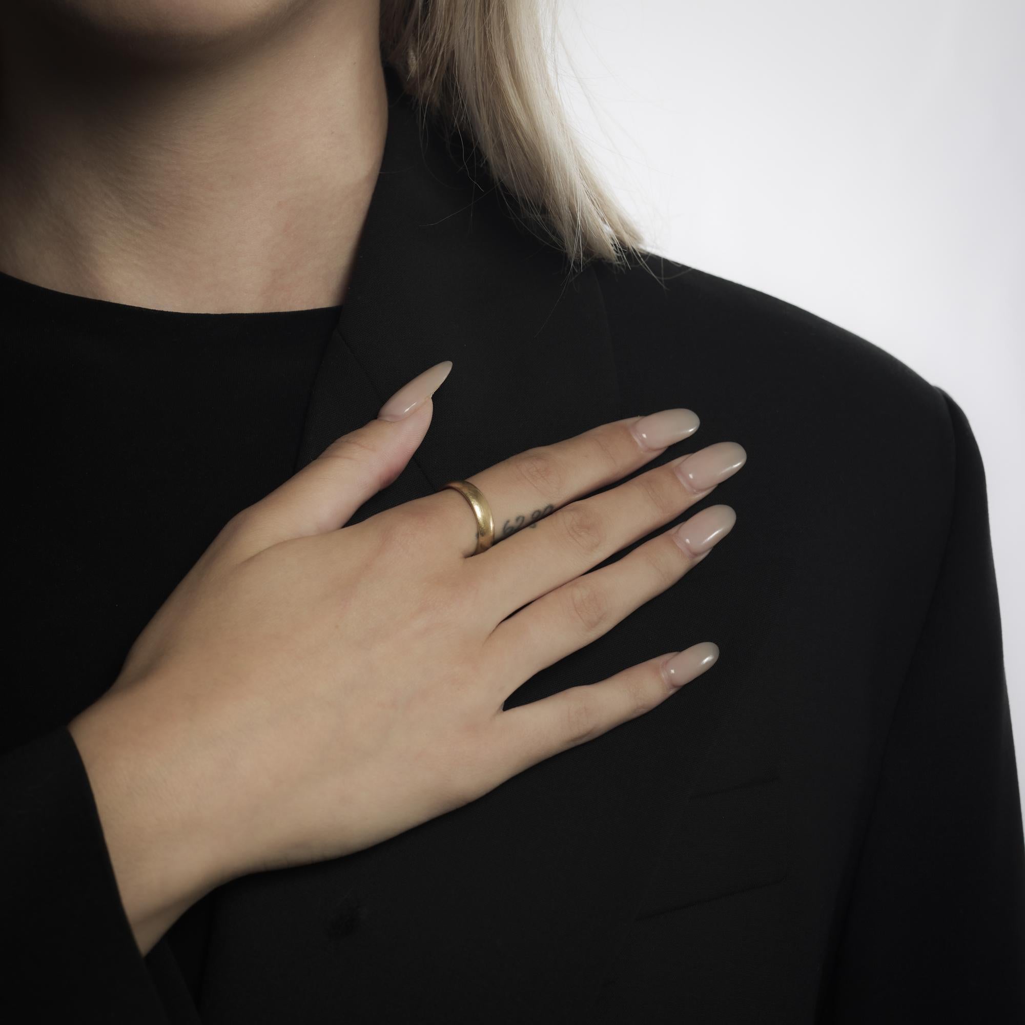 This vintage 14k yellow gold ring from the 1990’s features a smooth, lustrous band with a timeless design. The warm glow of the gold is complemented by its clean lines and classic profile, making it versatile for daily wear or as part of a layered