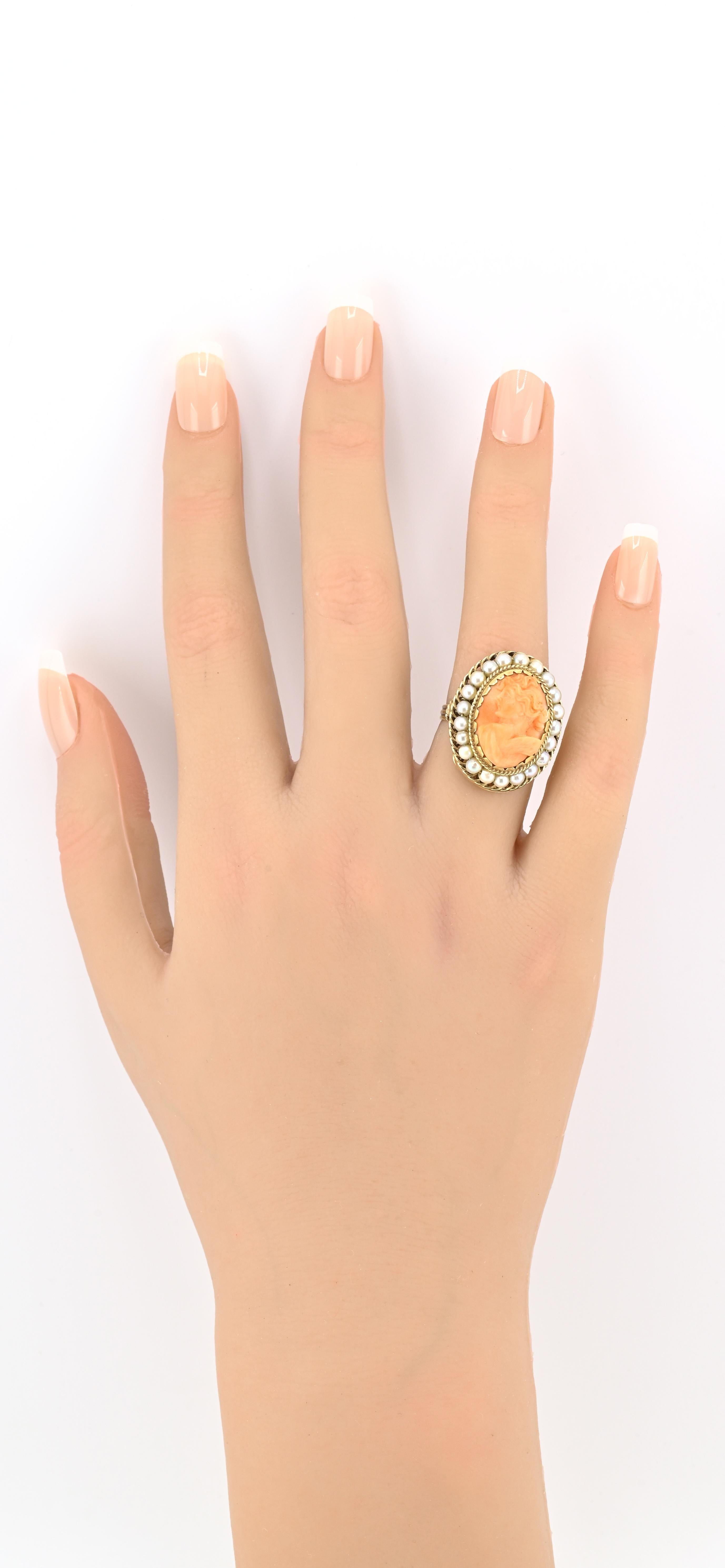 Dieser exquisite Vintage-Ring ist aus massivem 14-karätigem Gelbgold gefertigt und zeigt in der Mitte eine wunderschön handgeschnitzte Korallen-Kamee. Die Kamee zeigt ein detailliertes klassisches Profil in einem satten, natürlichen Korallenton,