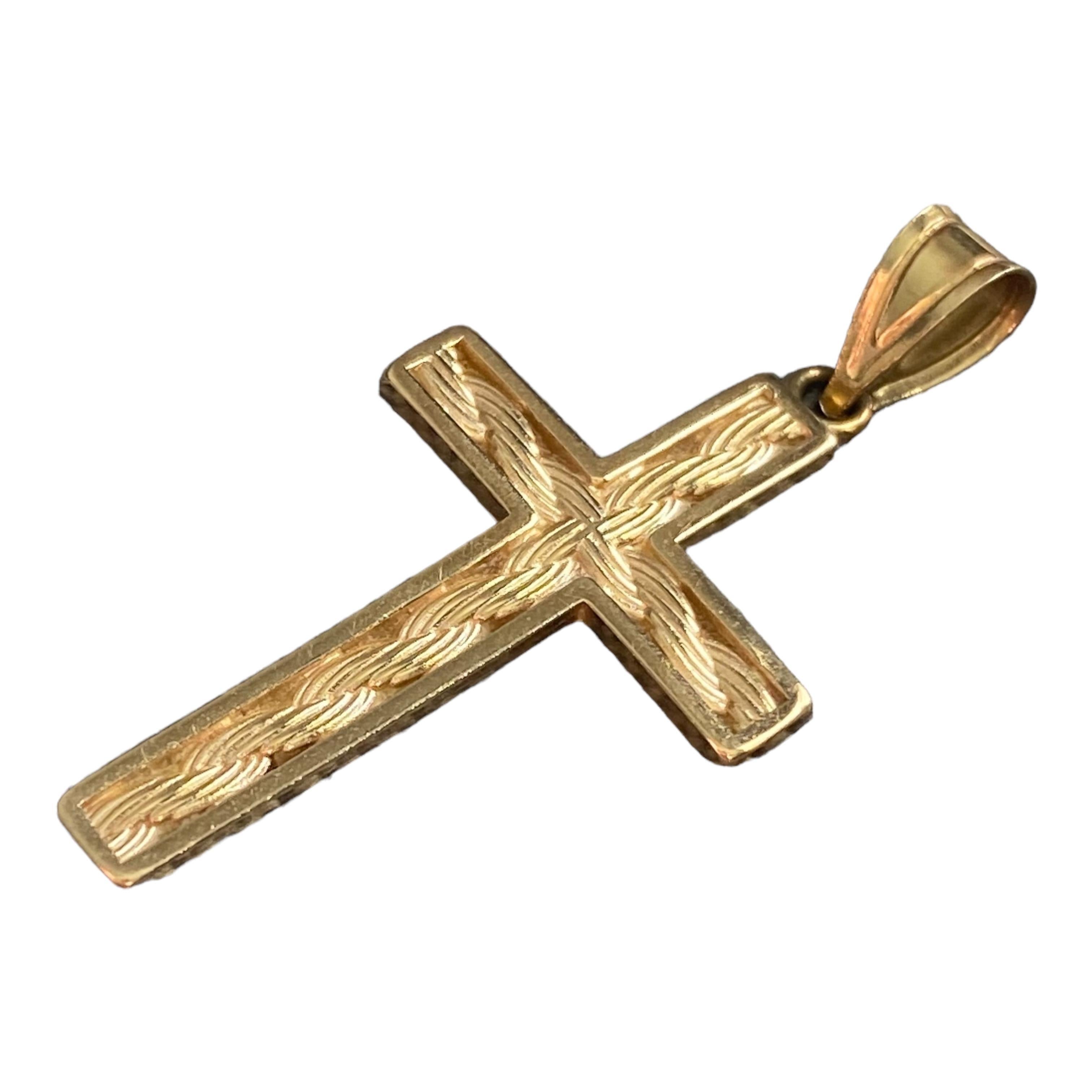 Crafted in 14K yellow gold, this pendant features a cross design with intricate rope style engraved patterns along its surface. The cross is elegantly proportioned, with a polished finish that highlights the detailed