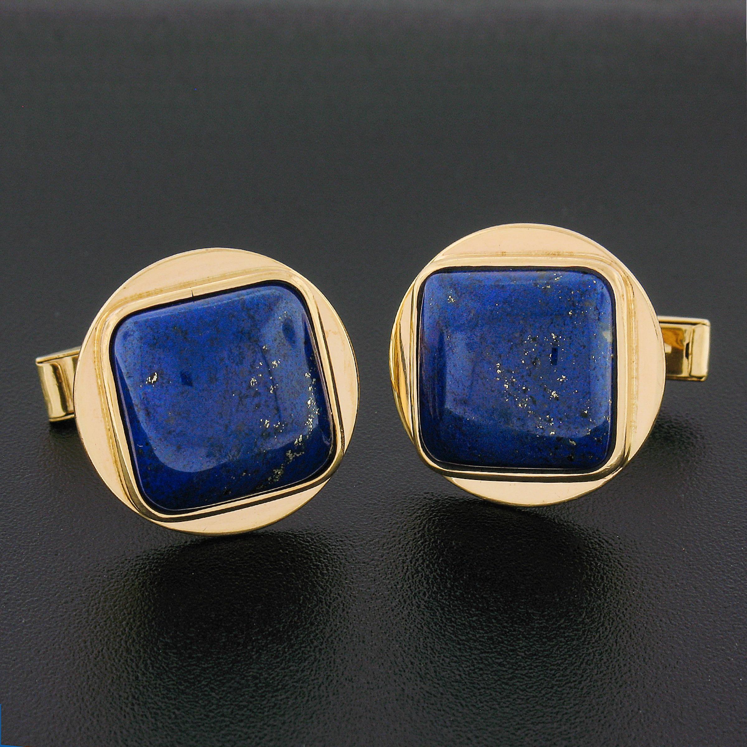 This vintage pair of cuff links was crafted in solid 14k yellow gold. The cuff links feature 2 cushion cabochon cut blue Lapis stones. The lapis are bezel set onto the round shaped panel. The cuff links have polished finish and swivel backings that