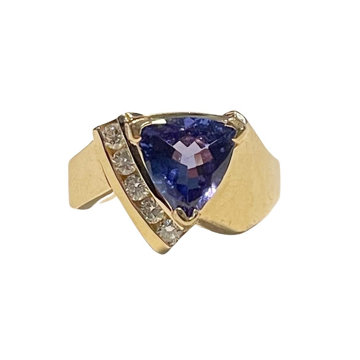 This unique piece is crafted in 14K yellow gold, the geometric shanks give this piece an artistic look. Along the center gem is a channel setting holding five round cut diamonds giving the ring a beautiful crisp splash of white. In the center is a