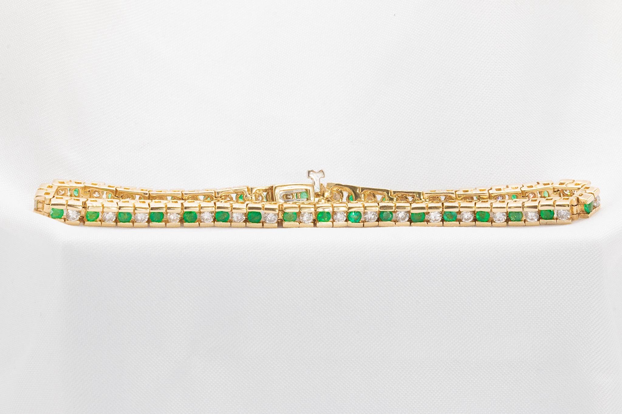 This stunning vintage 1980s 14K yellow gold bracelet showcases timeless elegance with 35 round-cut vibrant green emeralds totaling approximately 1.4 carats. These exquisite emeralds are beautifully accented by 34 round brilliant diamonds, weighing