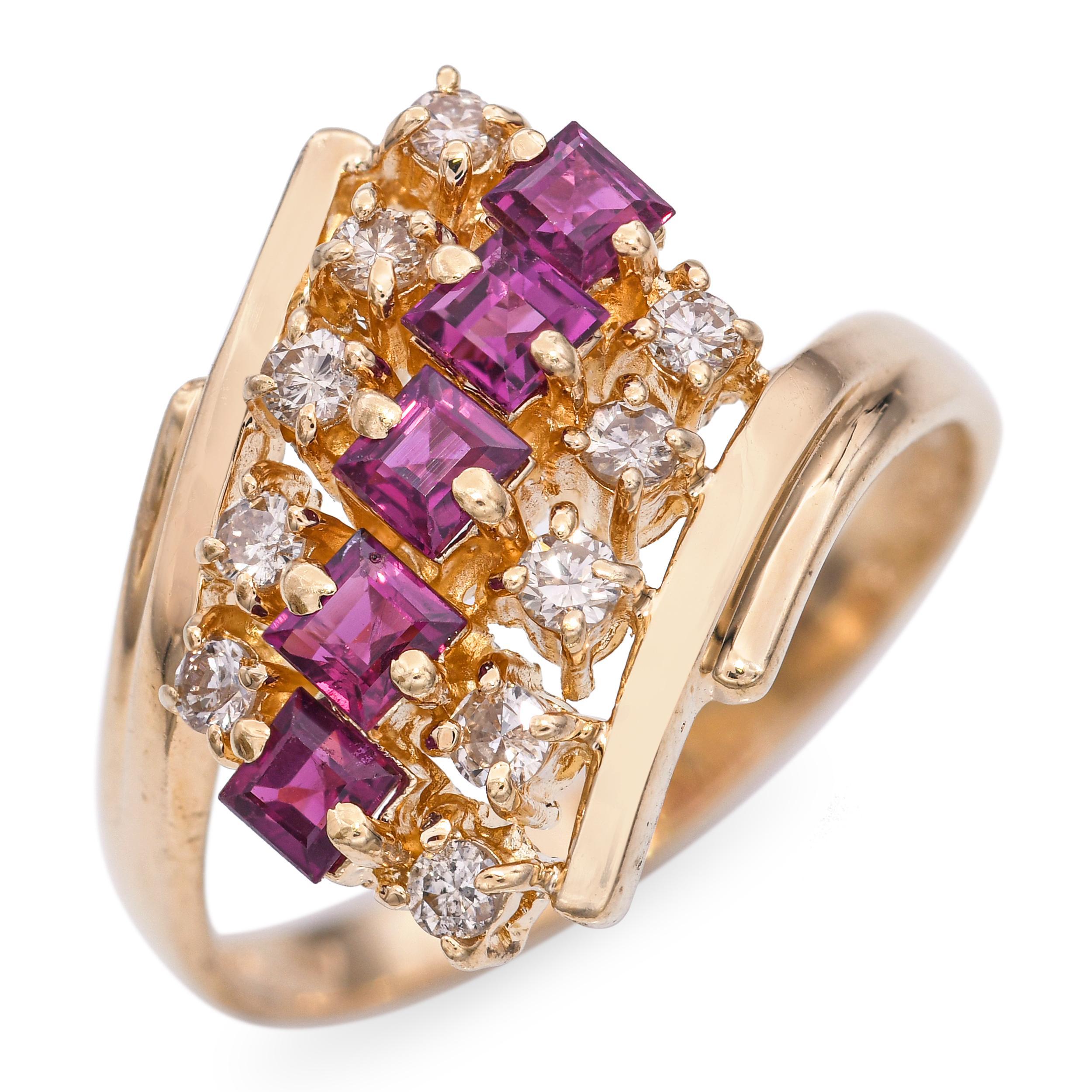 Crafted in 14k yellow gold, this vintage ring features a bypass design with a central arrangement of diamonds and rubies nestled between the open, twisted shoulders. The gemstones form a vivid, linear bridge that unites the split band in a striking