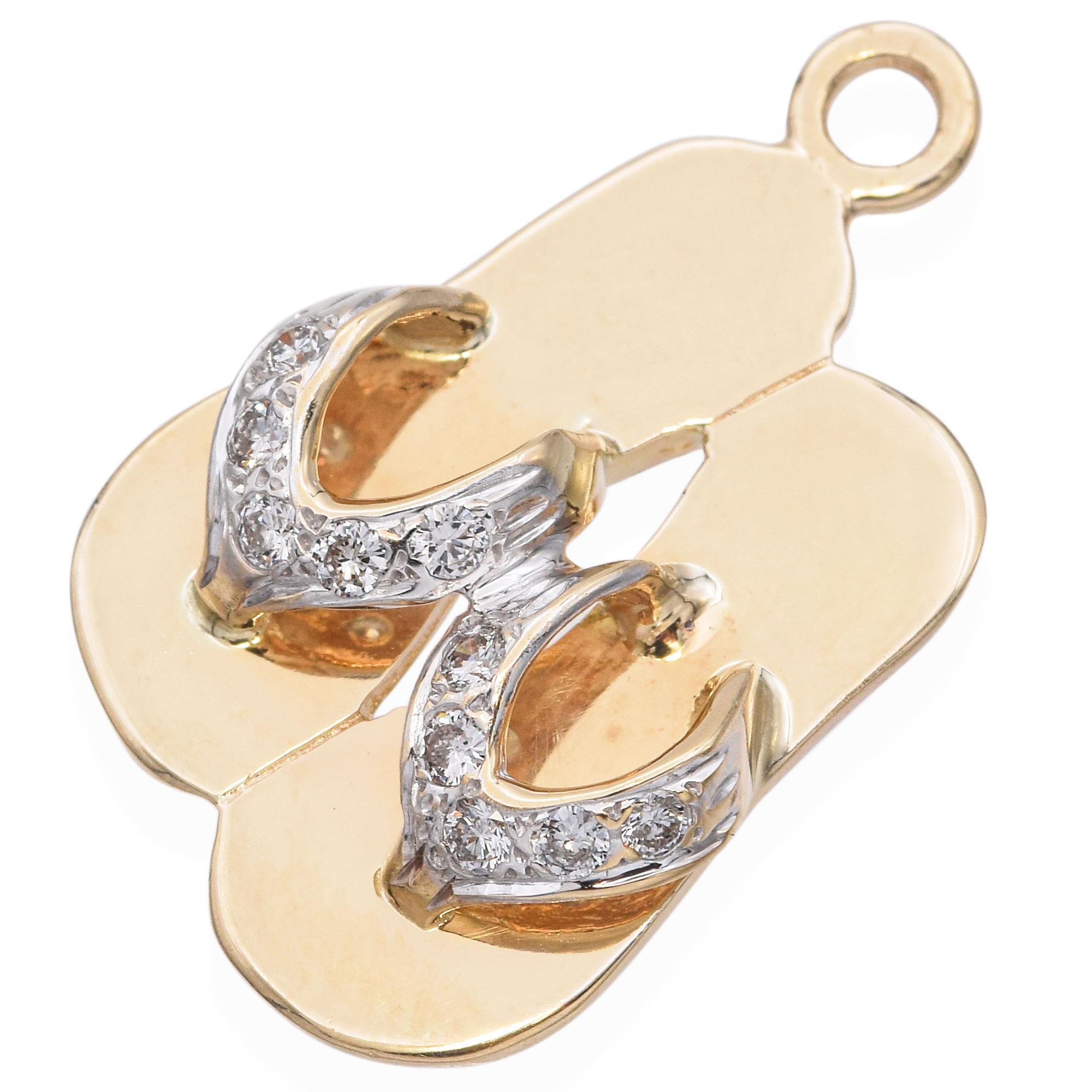 This charm features a playful flip-flop design in polished gold, accented with sparkling stones on the straps. A charming piece that adds a touch of whimsy and elegance to any collection.

Weight: 2.8 grams 
Stone: Pave Diamonds 
Measurements: 23.3
