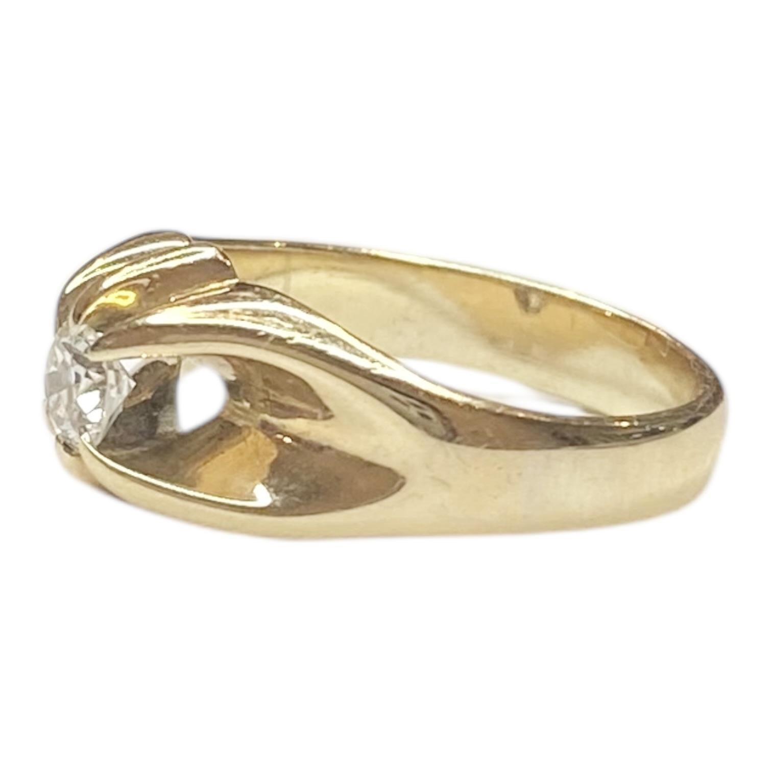 Anillo solitario vintage de oro amarillo de 14k con un diamante de talla europea antigua. El diseño presenta una banda abierta única con una forma fluida y escultural. El diamante está engastado de forma prominente en el centro, realzando su brillo.