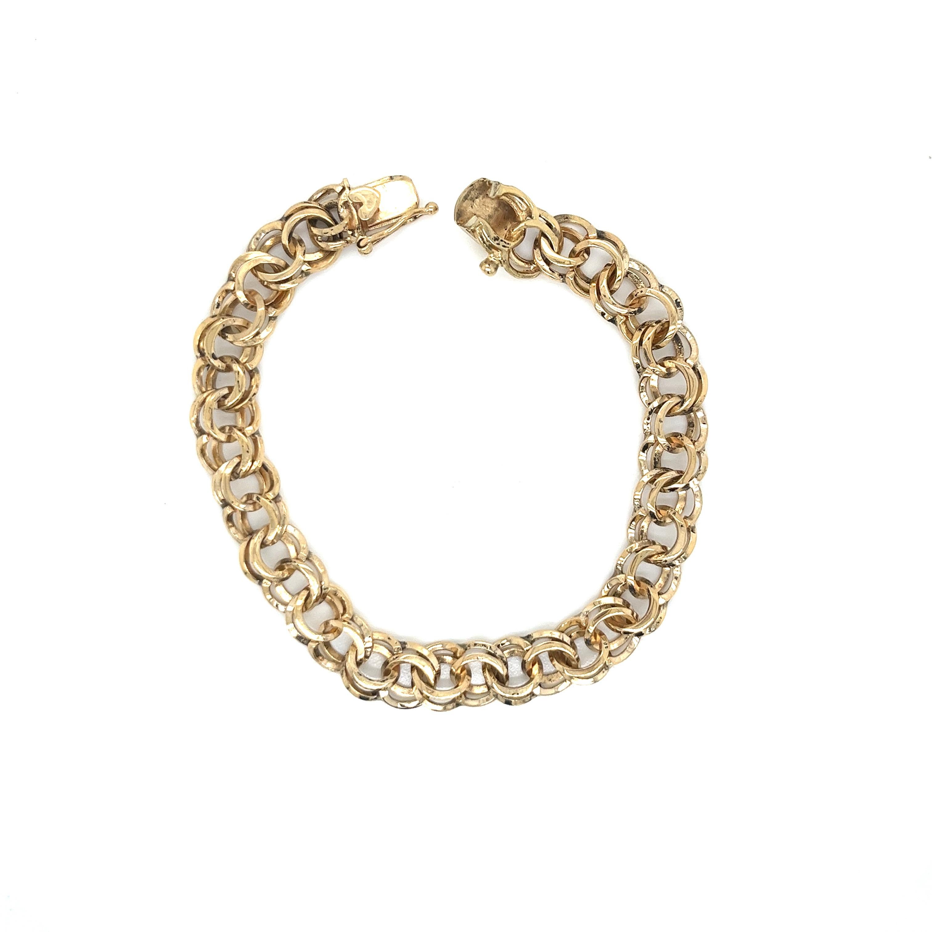This exquisite 14k yellow gold double link charm bracelet is a true classic, showcasing the timeless allure of precious gold and the versatility of a traditional double link design. Crafted with impeccable attention to detail, it exudes a warm,