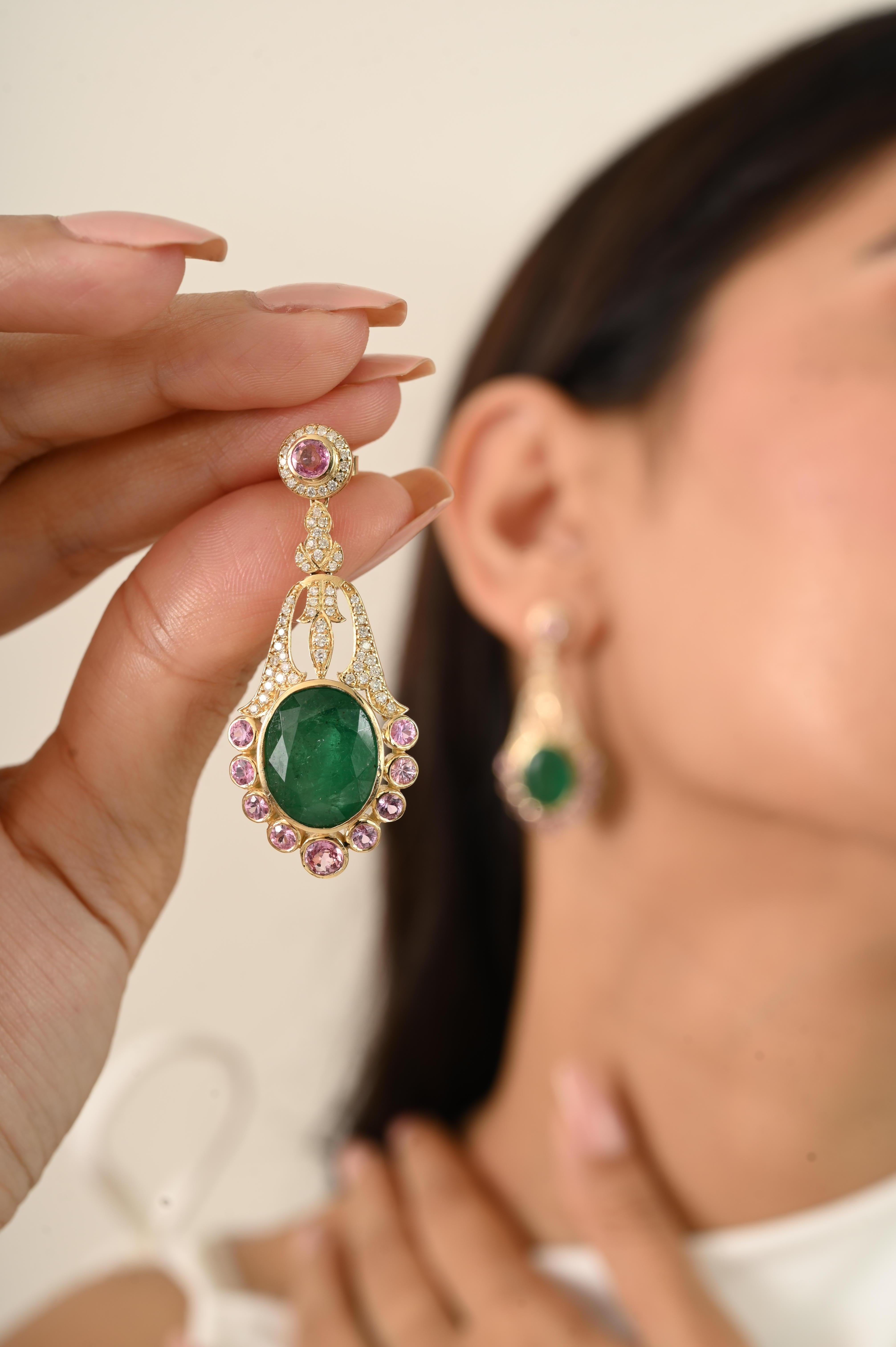Vintage 14k Yellow Gold 17.67 carats Emerald & Pink Sapphire Chandelier Earrings beautifully accented with of 0.77 carats brilliant Diamond Designed in an elegant chandelier style, each earring features a bold oval-cut emerald at the center,