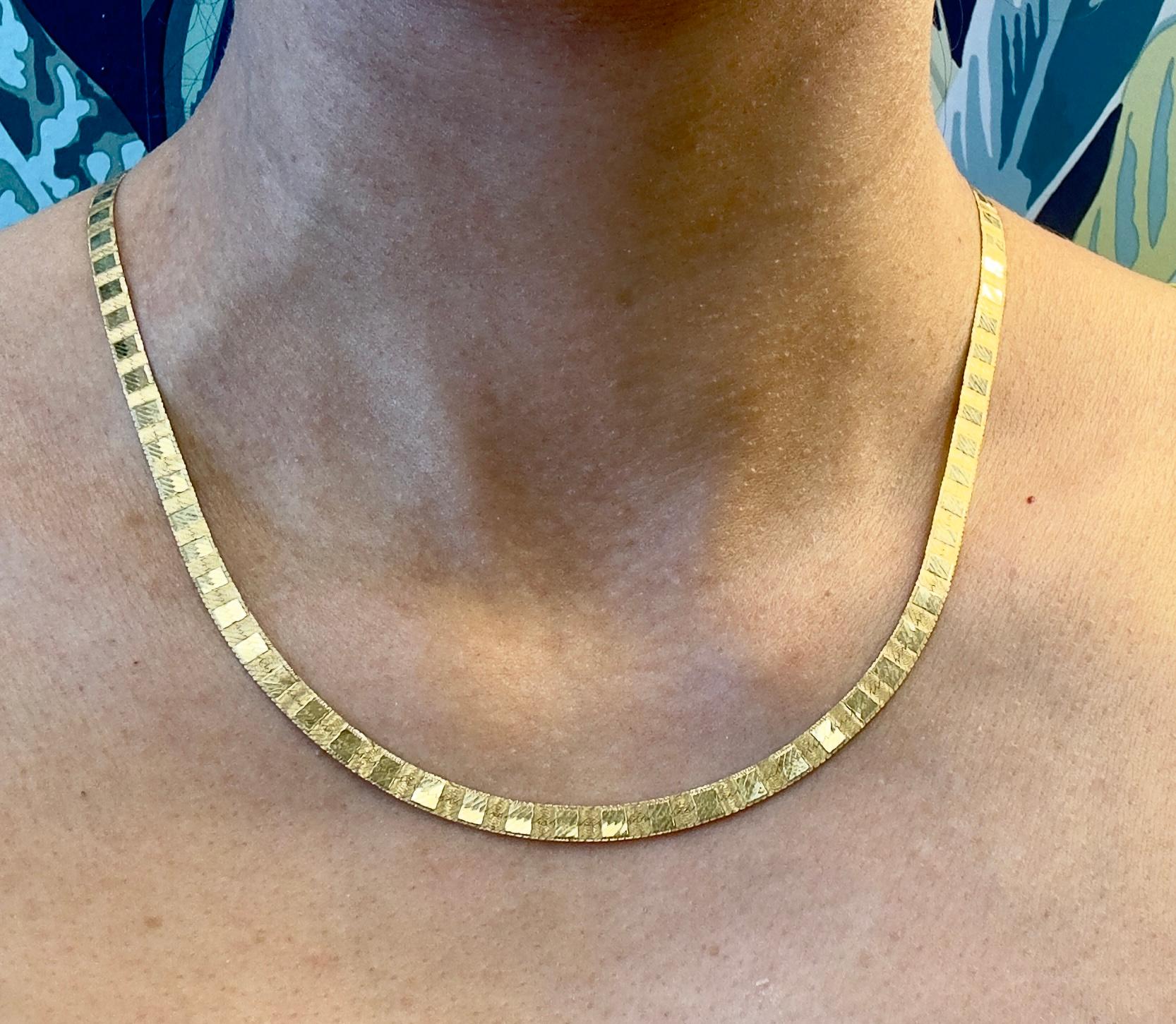 This exquisite vintage herringbone necklace is crafted in 14K yellow gold, featuring an elegant etched design that adds unique texture and charm. With a substantial width of 4.5mm and a length of 19 inches, this piece lays gracefully along the