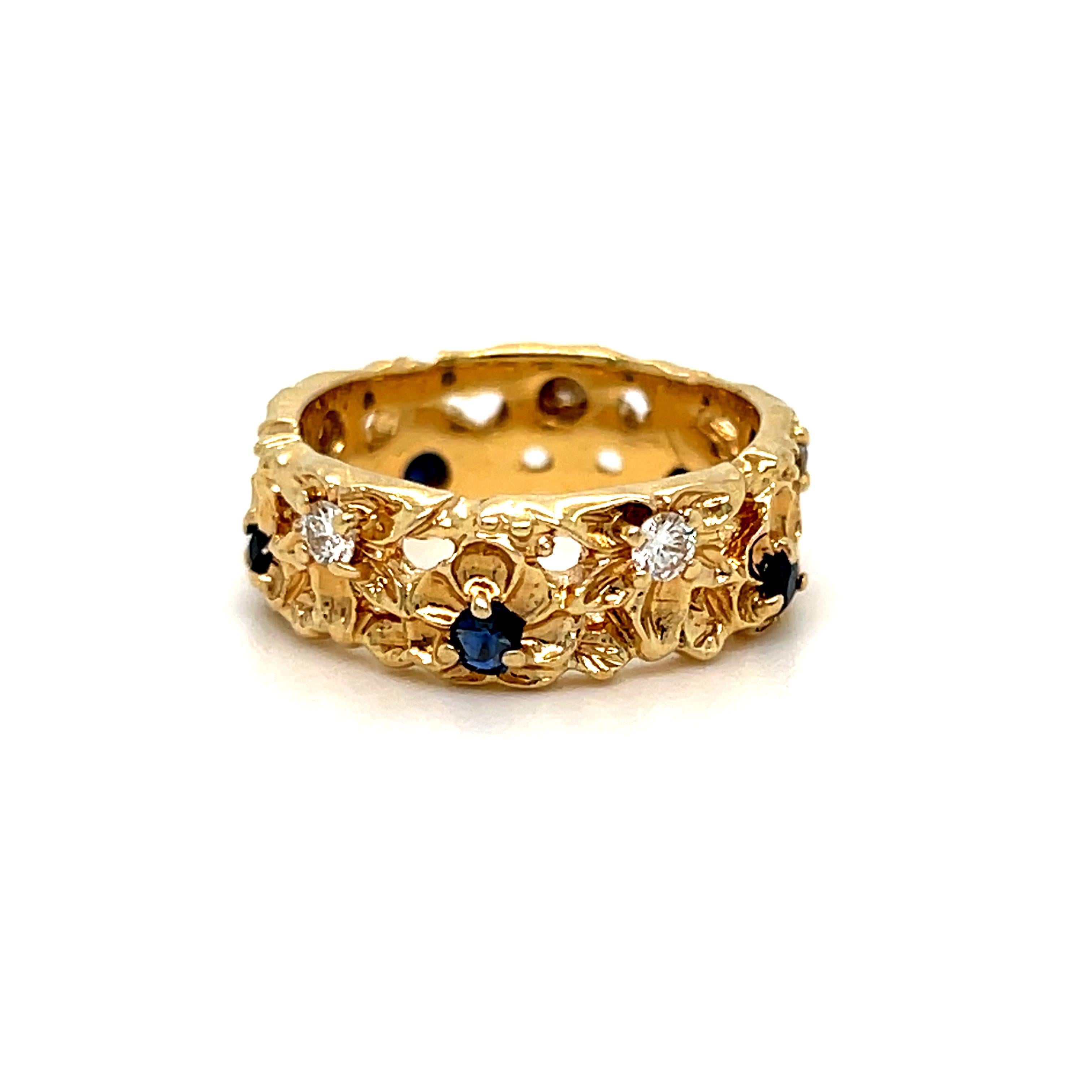This gorgeous Beautiful Vintage Floral Eternity Band Wedding Band with Diamonds and Sapphires is wonderfully one of a kind! Crafted in 14K Yellow Gold, the design is of handcrafted floral blooms in eternity around the band, and set with alternating
