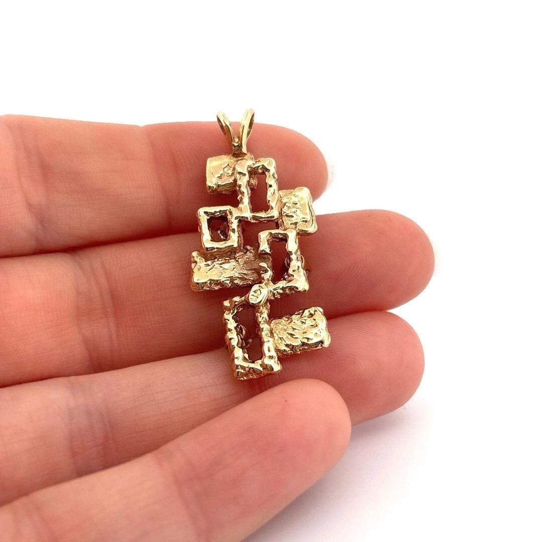 This unique vintage pendant is crafted in solid 14K yellow gold and features a striking freeform, openwork design with an organic modernist aesthetic. The geometric layout is artistically textured, giving it sculptural dimension and visual interest.