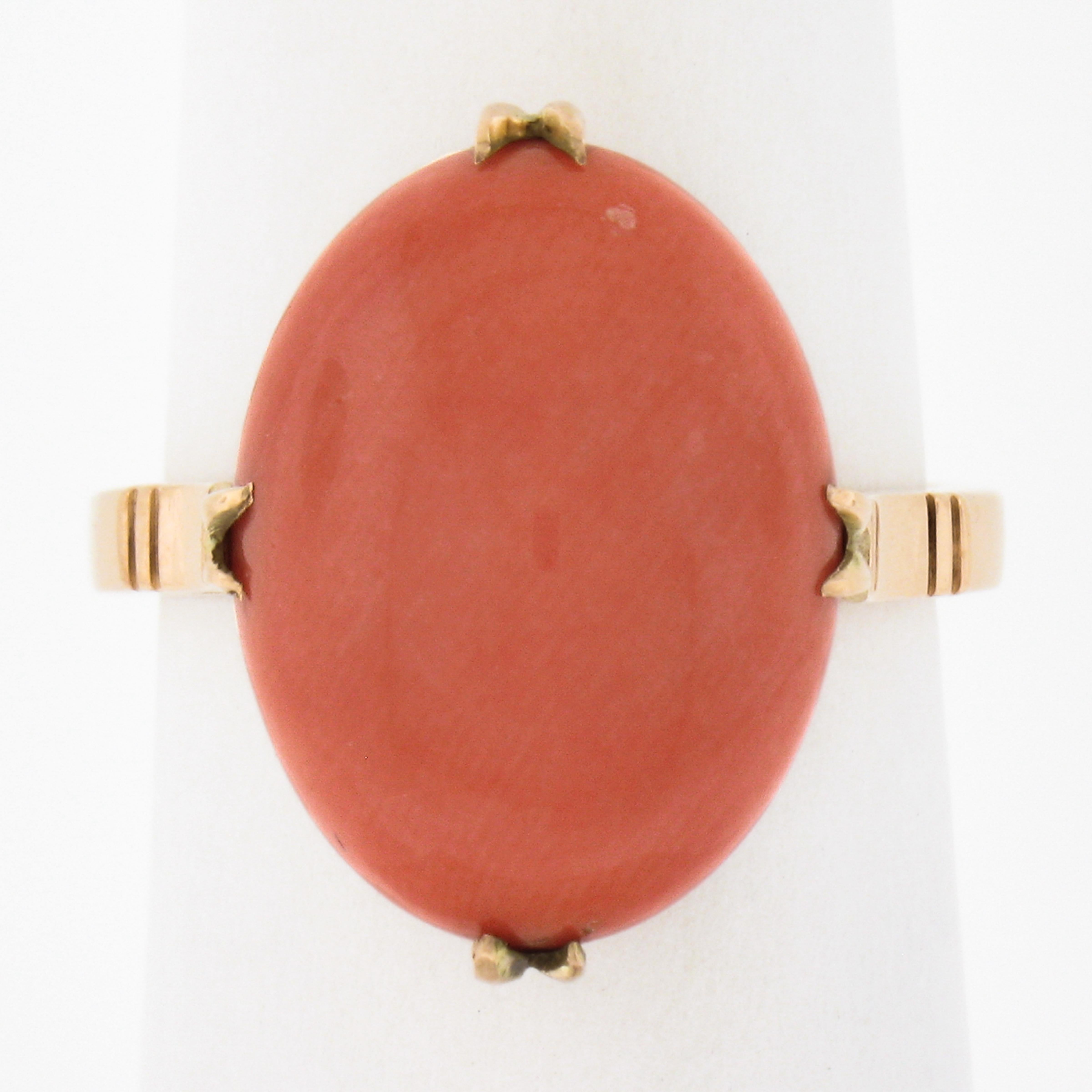 Este anillo de coral vintage, clásico y realmente maravilloso, está muy bien elaborado en oro amarillo de 14 quilates y presenta una magnífica piedra de coral natural certificada por el GIA. El coral muestra un color naranja salmón muy agradable y