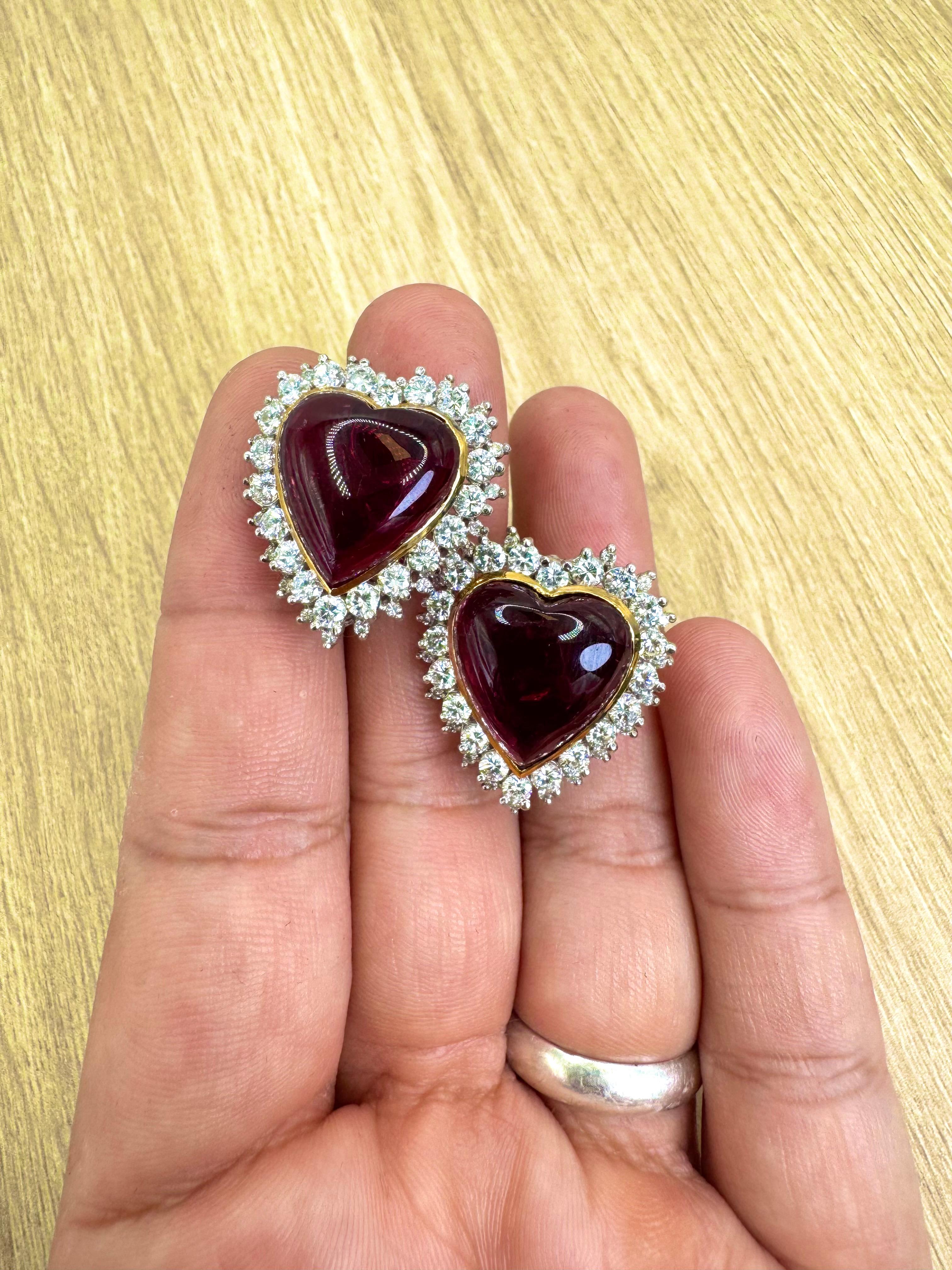 Make a bold romantic statement with these exquisite vintage ear clips, crafted in 14K yellow gold. Each earring features a richly hued, heart-shaped rubellite tourmaline cabochon—together weighing approximately 22.63 carats—set in warm gold bezels